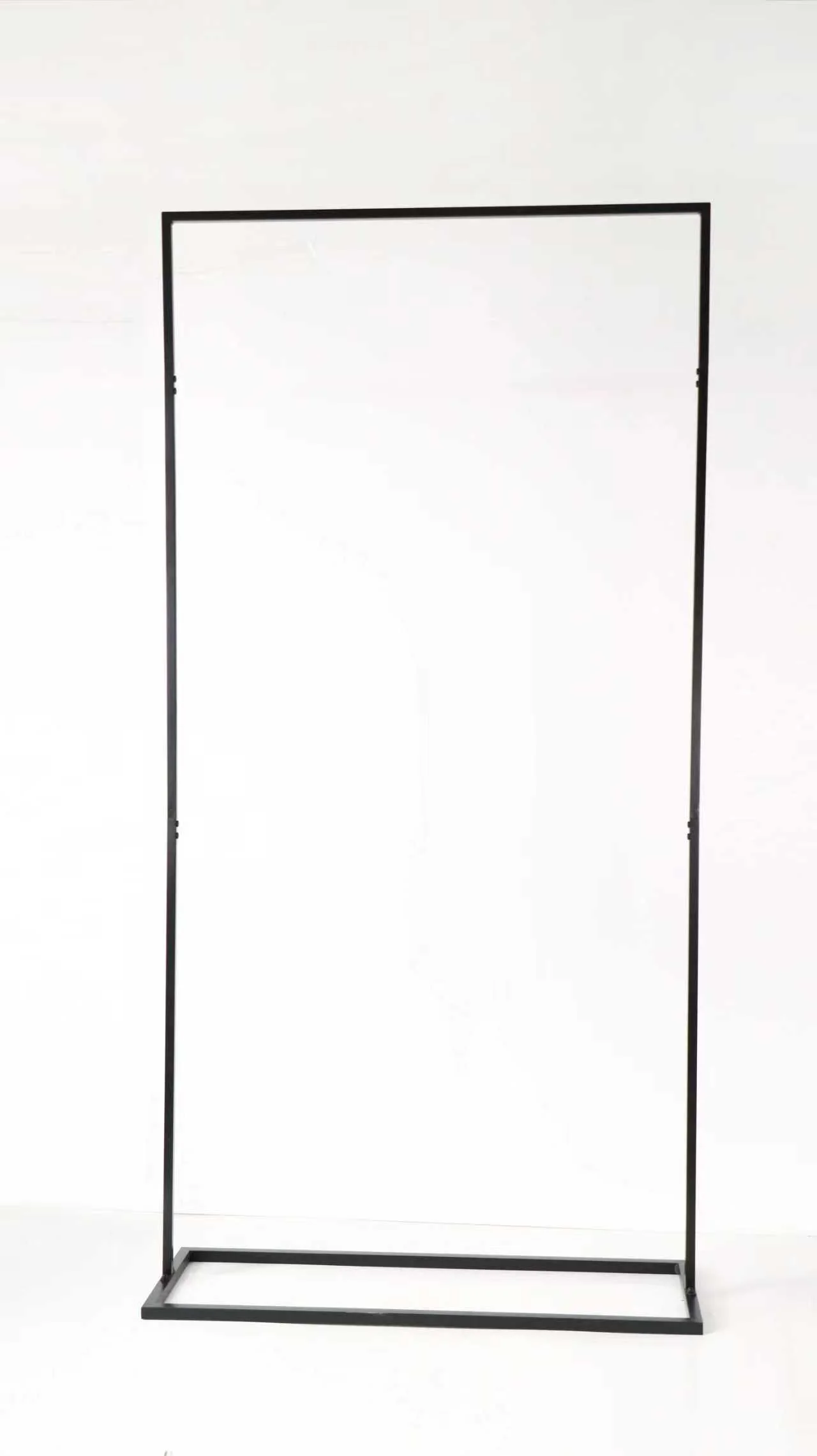 Empty black metal clothing rack frame on a white background.