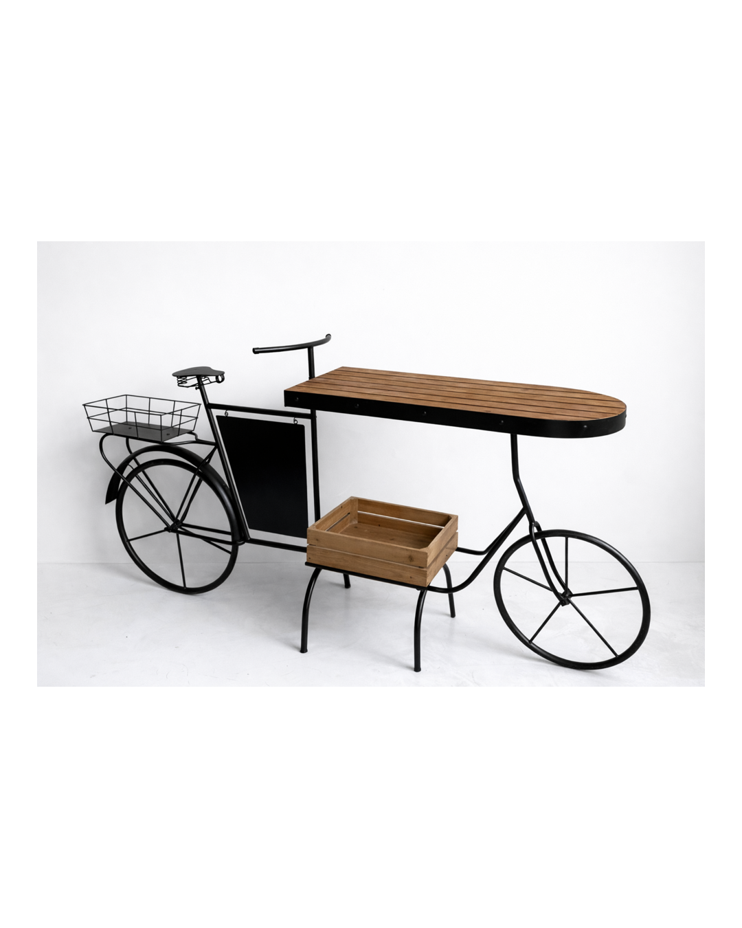 A bicycle-shaped table with wooden top and accents, featuring a wire basket on the rear and a wooden box on the lower rack, set against a white background.
