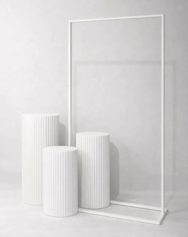 Three white pedestals with vertical ridges and a white rectangular frame on a white background.