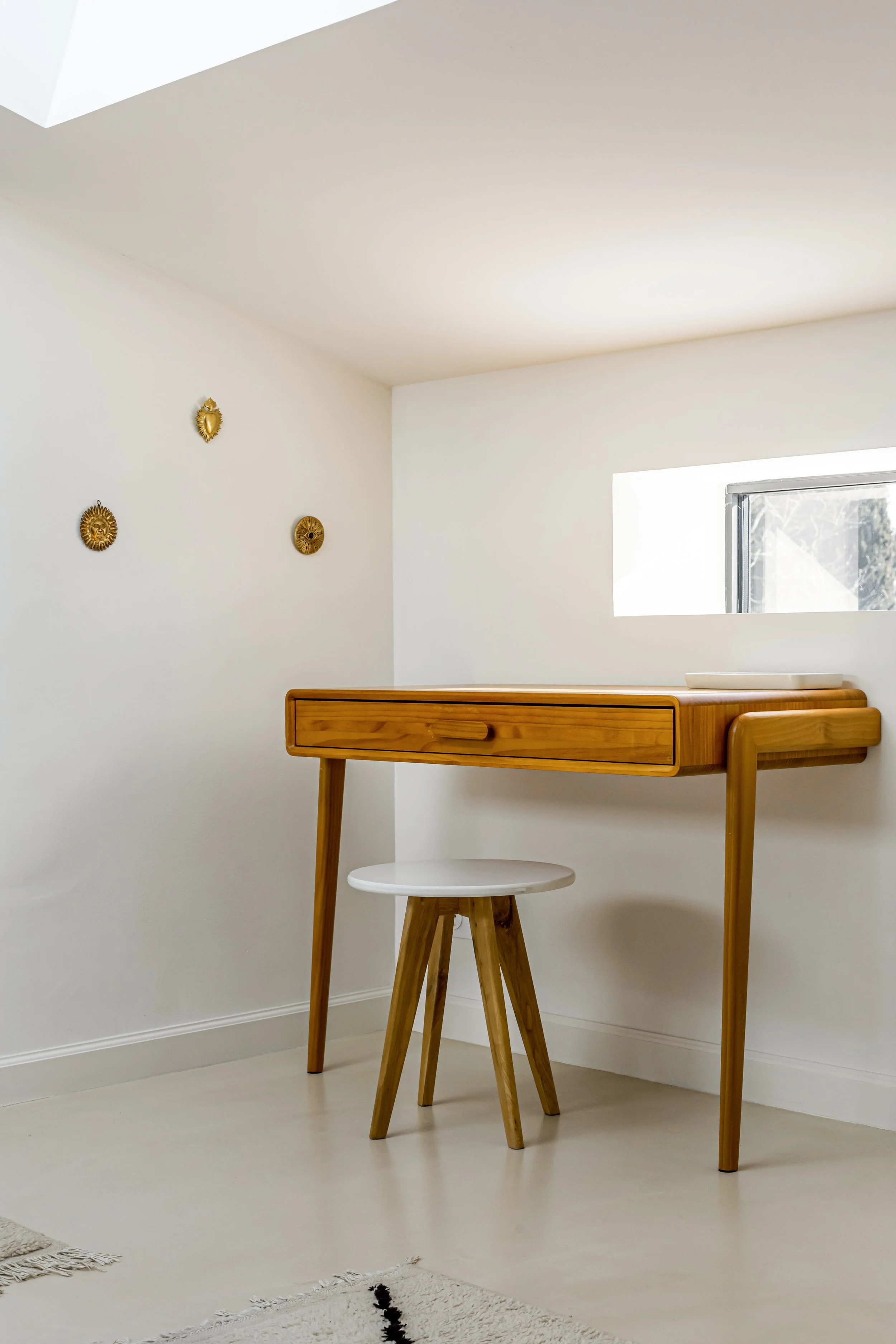 Intérieur minimaliste avec espace bureau intégré à la chambre parentale , une petite assiette blanche, un tabouret en bois, et des décorations en or sur le mur realisation Laure Galippe , architecte d'intérieur à Aix-en-Provence