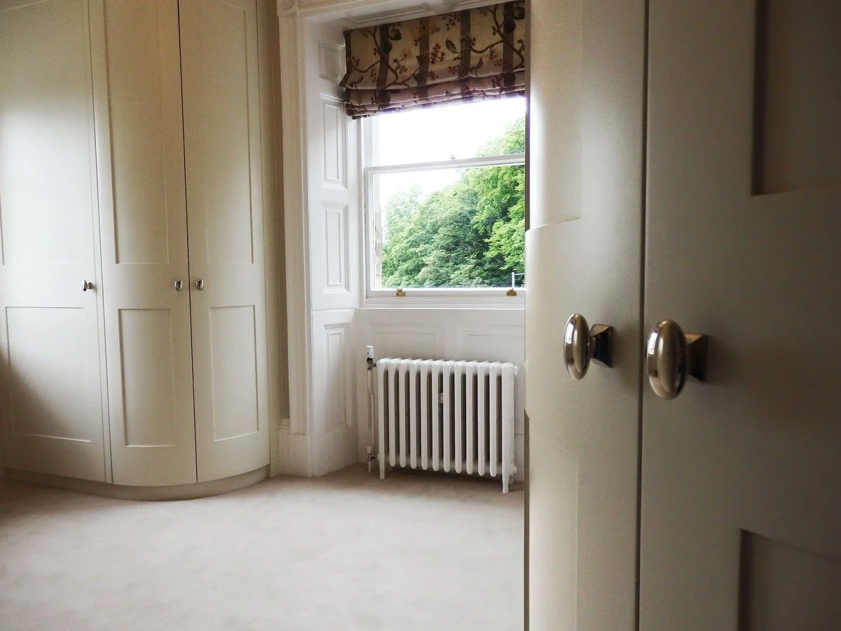 Curved walk-in dressing room and bedside dressers