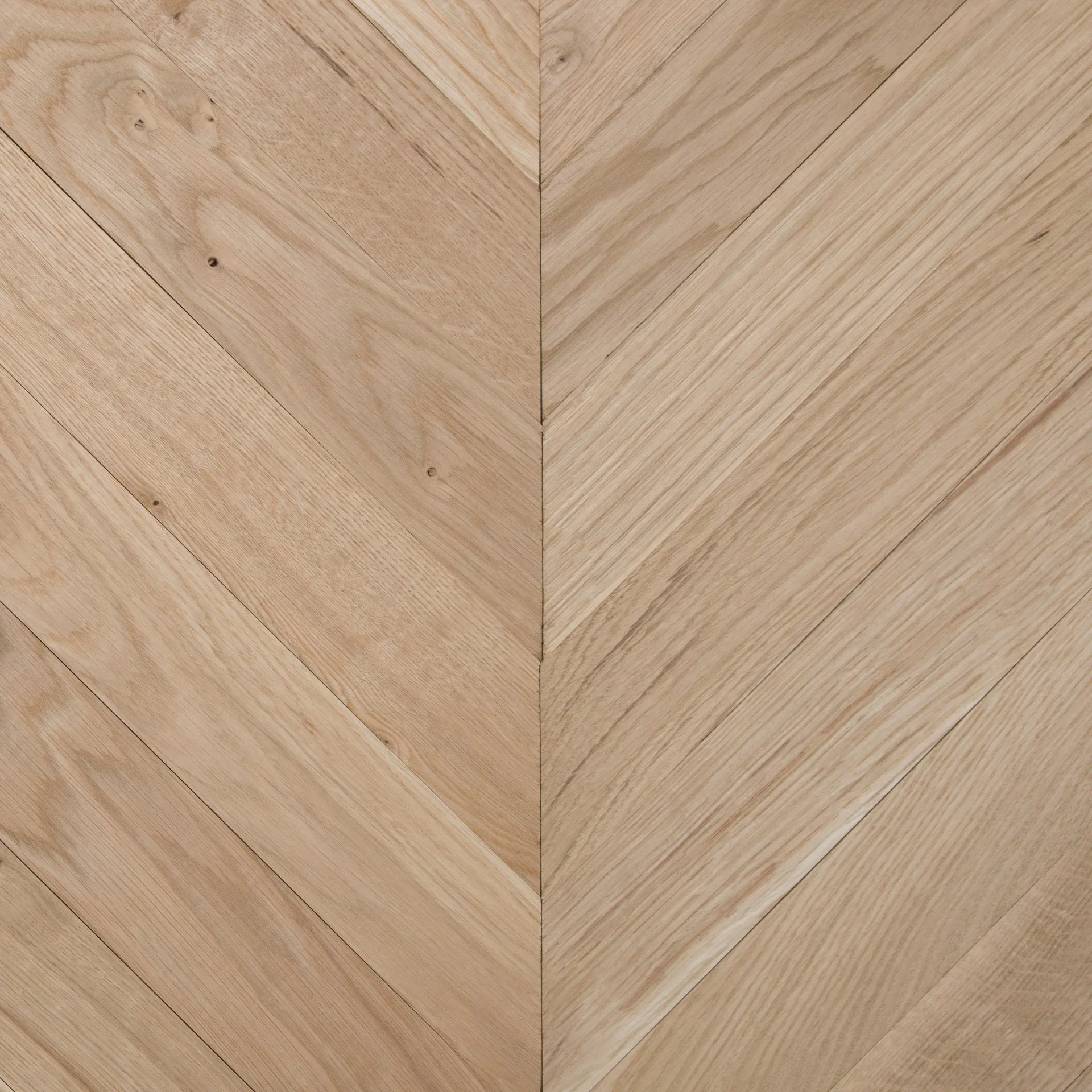 Close-up of light-colored wooden floorboards arranged diagonally, with visible wood grain and knots.