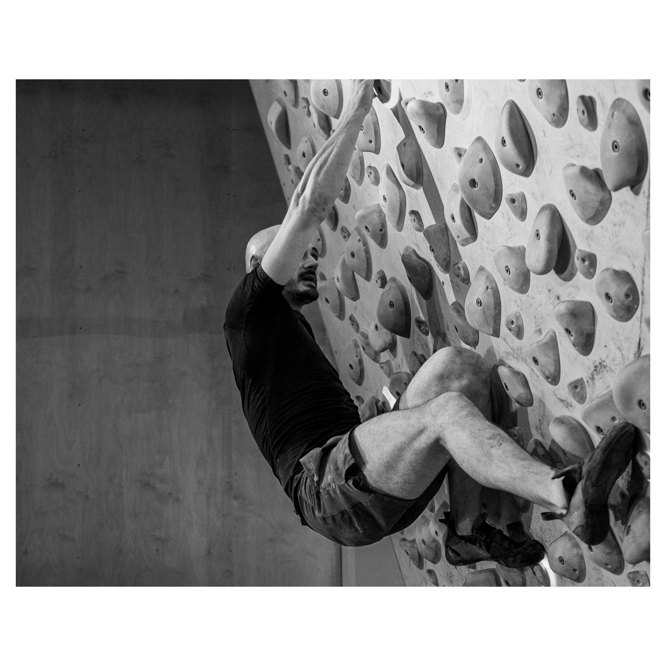 A man climbing an indoor rock climbing wall.