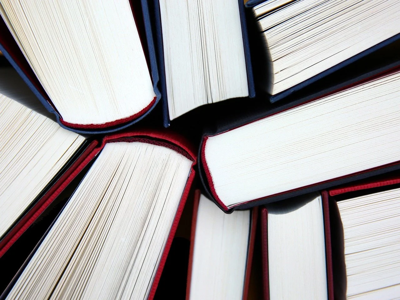 Bücherstapel von oben mit sichtbaren Seiten und Buchkanten.