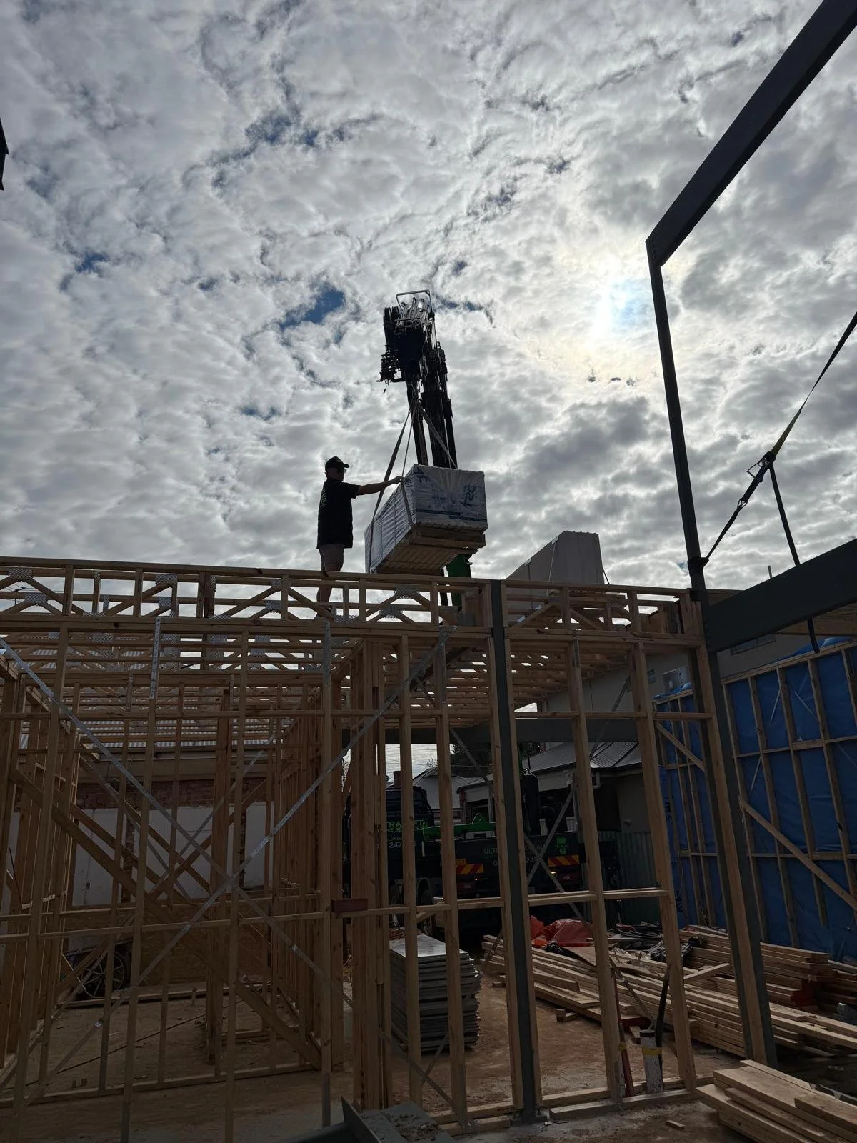 Picture of a crane delivering items to second story frame