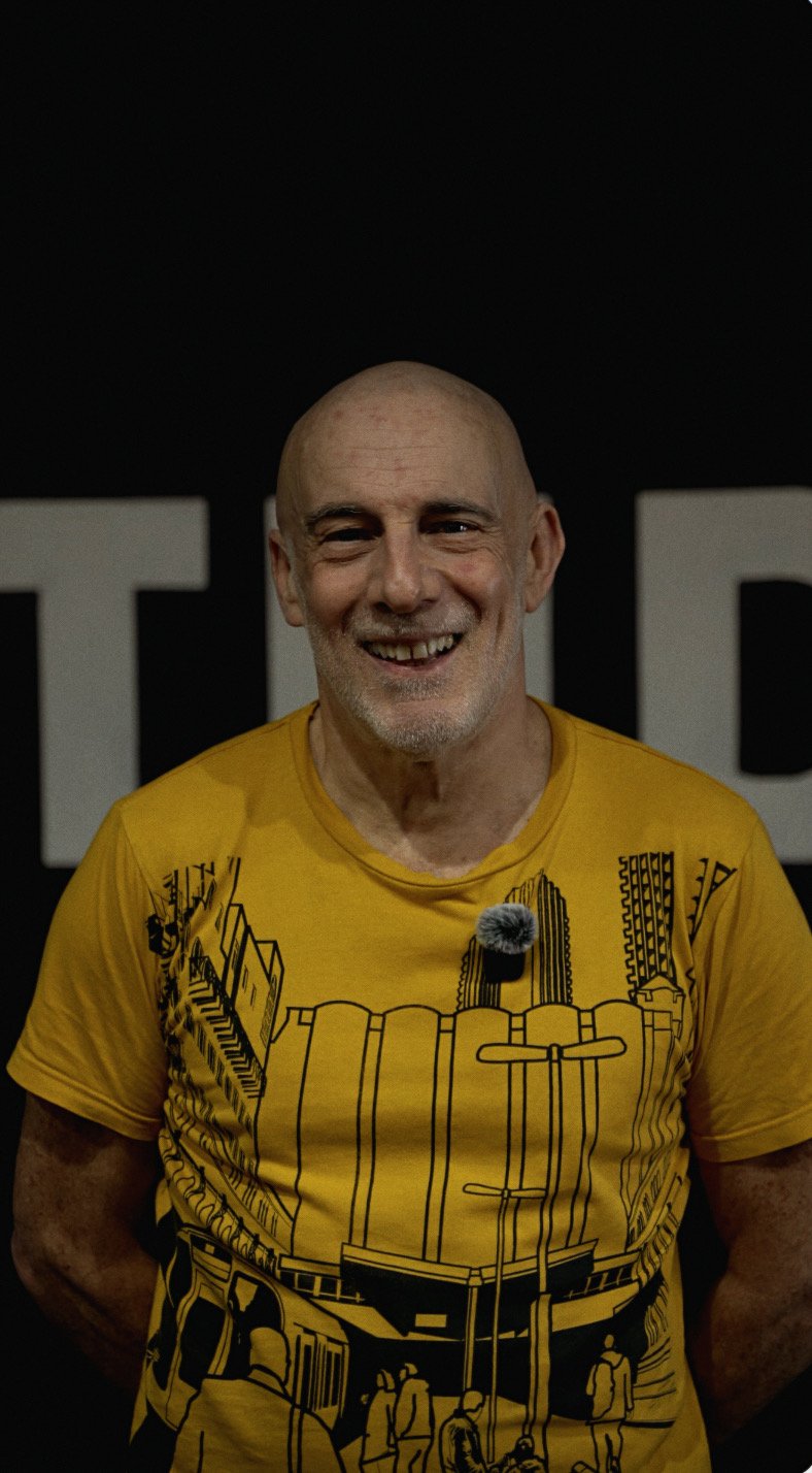 Older man smiling at the camera during a training session in a gym.