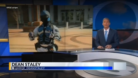 News broadcast with anchor Dean Staley reporting, featuring an outdoor scene with a person in a dark uniform and hat, and a blue background with graphical elements.