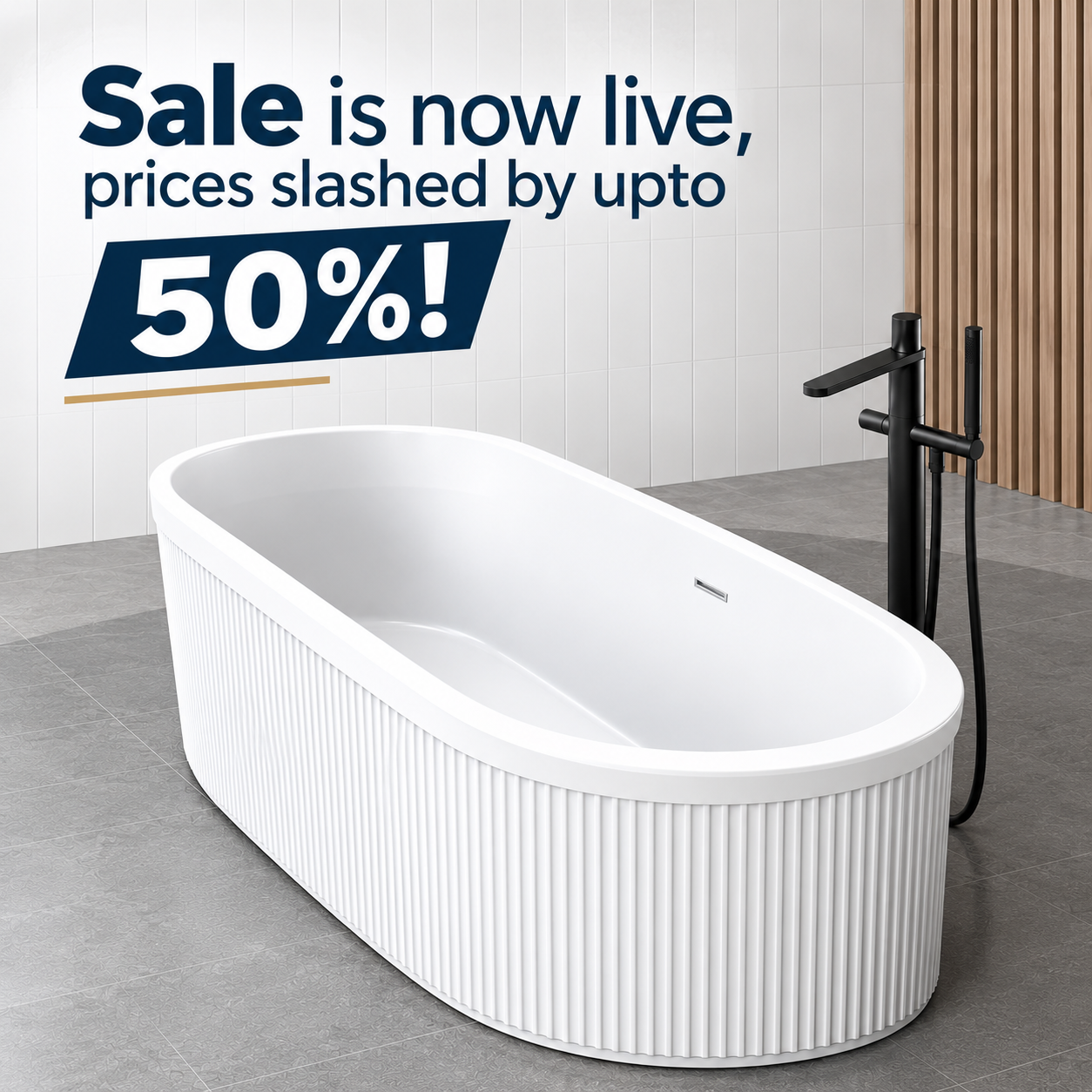 A modern bathroom features a white freestanding bathtub with vertical ridges on the exterior. There is a black floor-mounted faucet and handheld shower beside it. The background wall has a large sale sign in navy blue text that reads 'Sale is now live, prices slashed by up to 50%!' on a light tiled wall, with a wooden slat accent wall on the right.