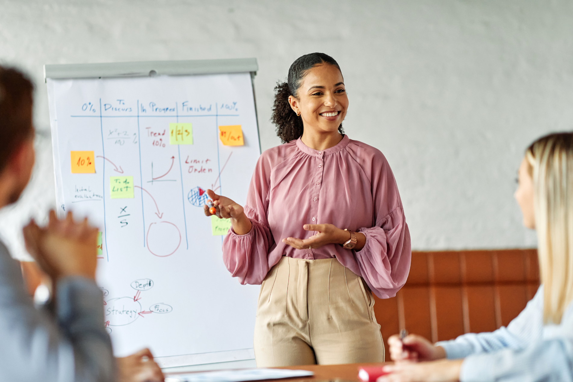 Female manager wearing a pink top standing in an office
