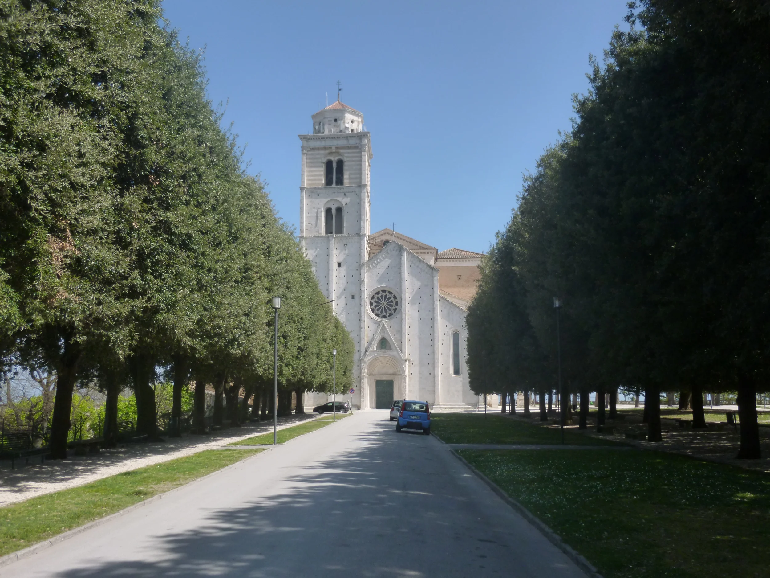 The cathedral of Fermo and its bell tower at the end of a tree-lined path in Girfalco Park