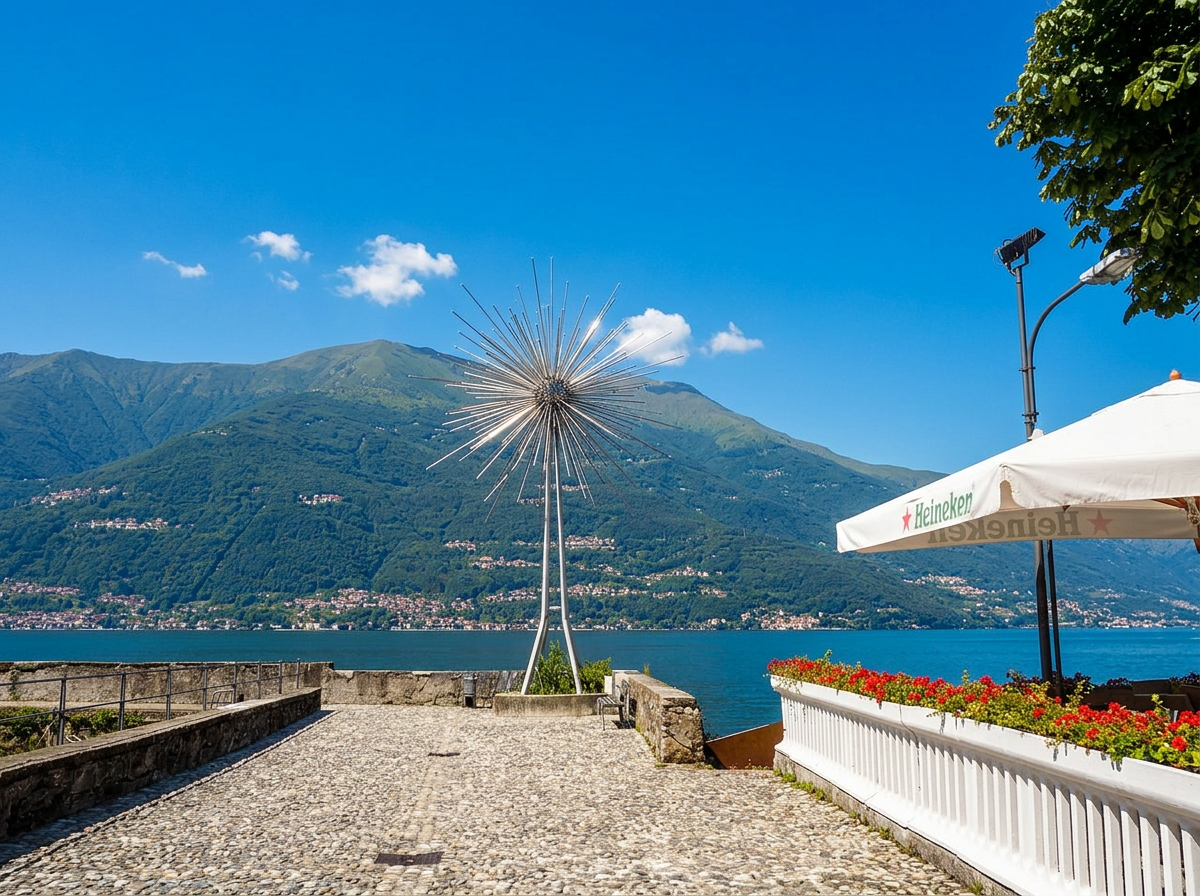 A lakeside terrace in Bellano with flowers, a metal sculpture and views across Lake Como.