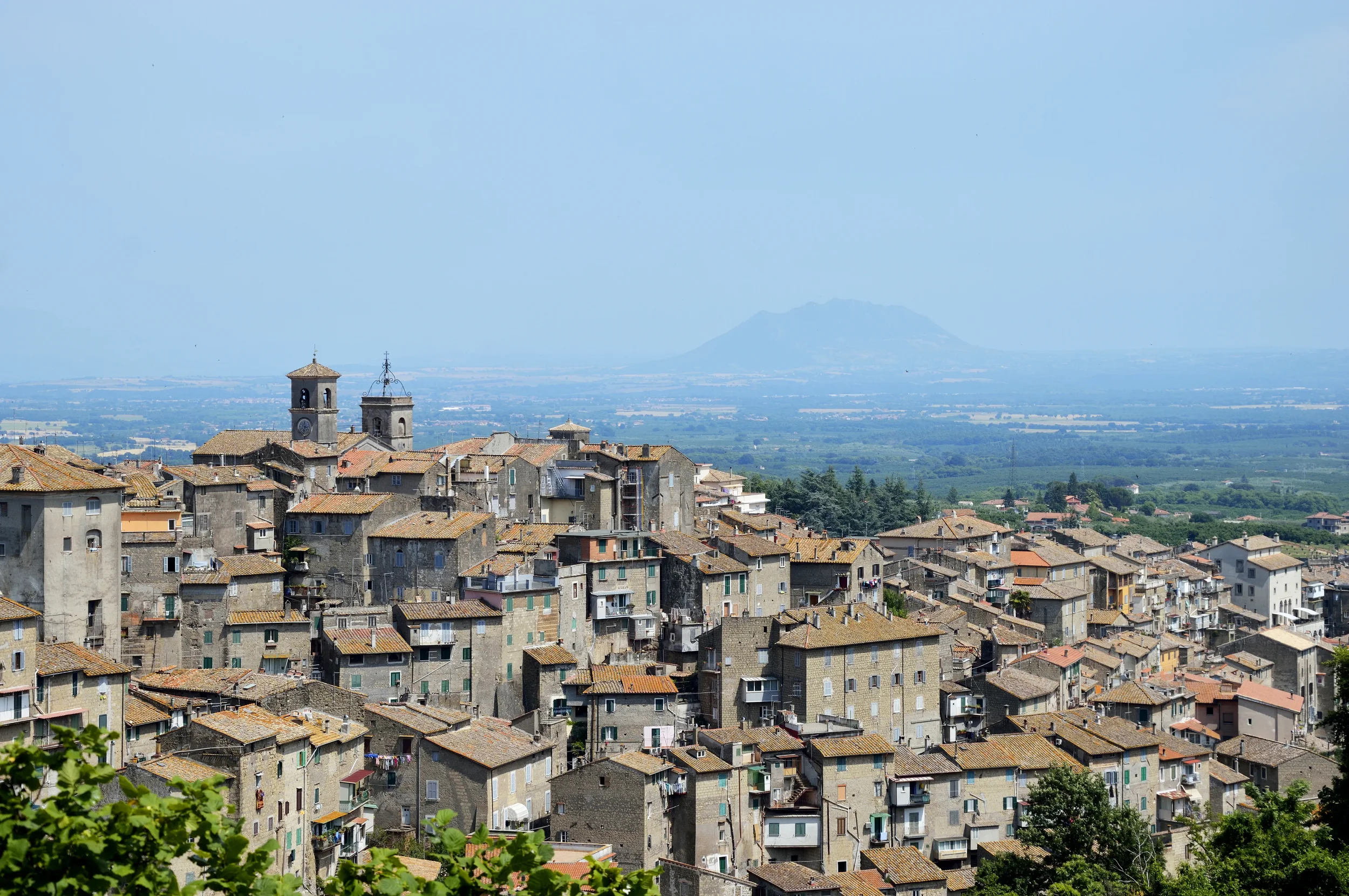 Terracotta rooftops and church towers in Caprarola, with the countryside stretching into the distance.