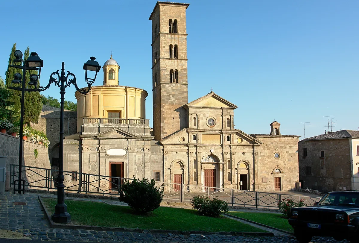 The façade and tall stone bell tower of the Basilica of Santa Cristina in Bolsena.