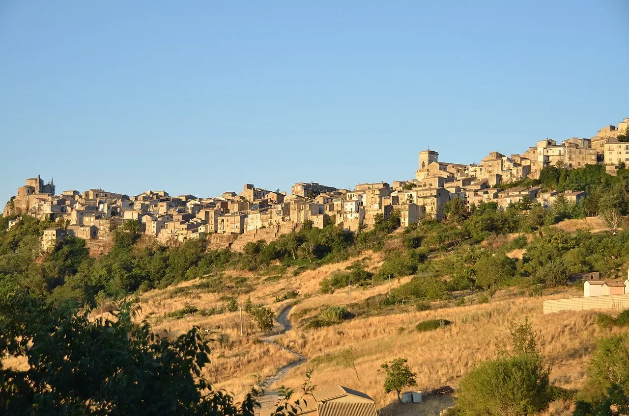 Petralia Soprana’s stone houses and church towers above a sunlit hillside in the Madonie mountains