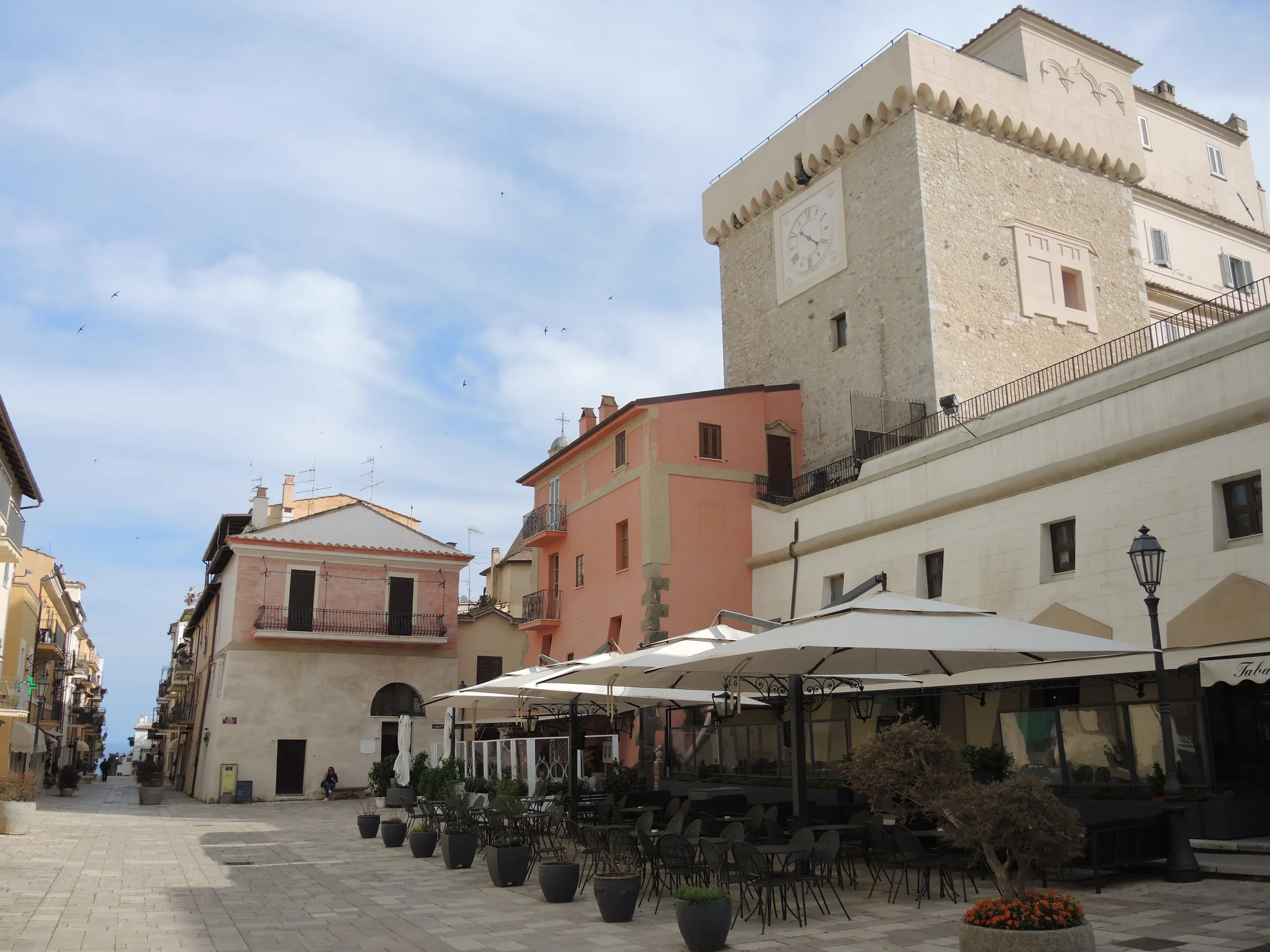 Café terraces beneath the Torre dei Templari in San Felice Circeo’s historic square.