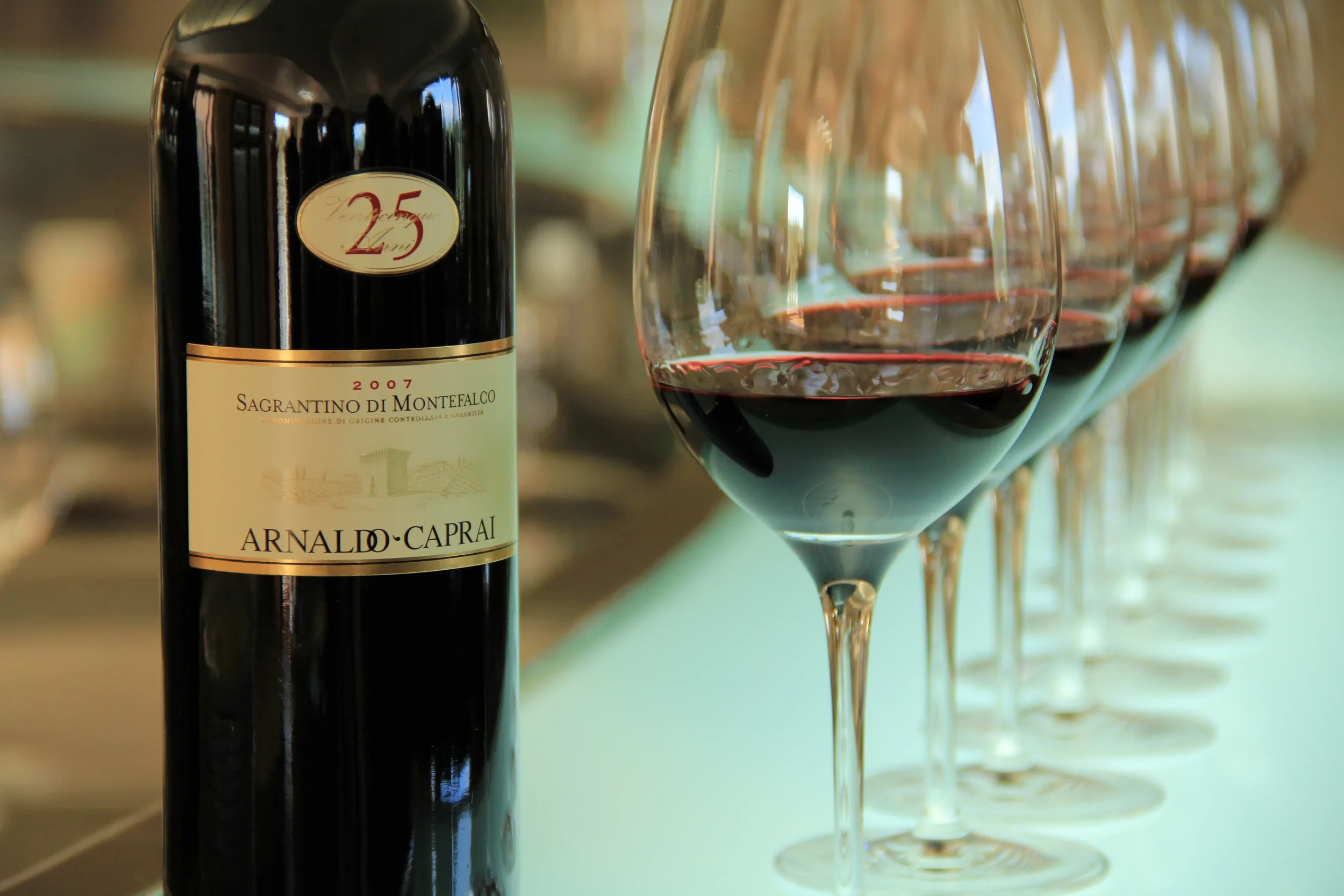 Bottle of Sagrantino di Montefalco wine beside glasses of red wine prepared for a tasting
