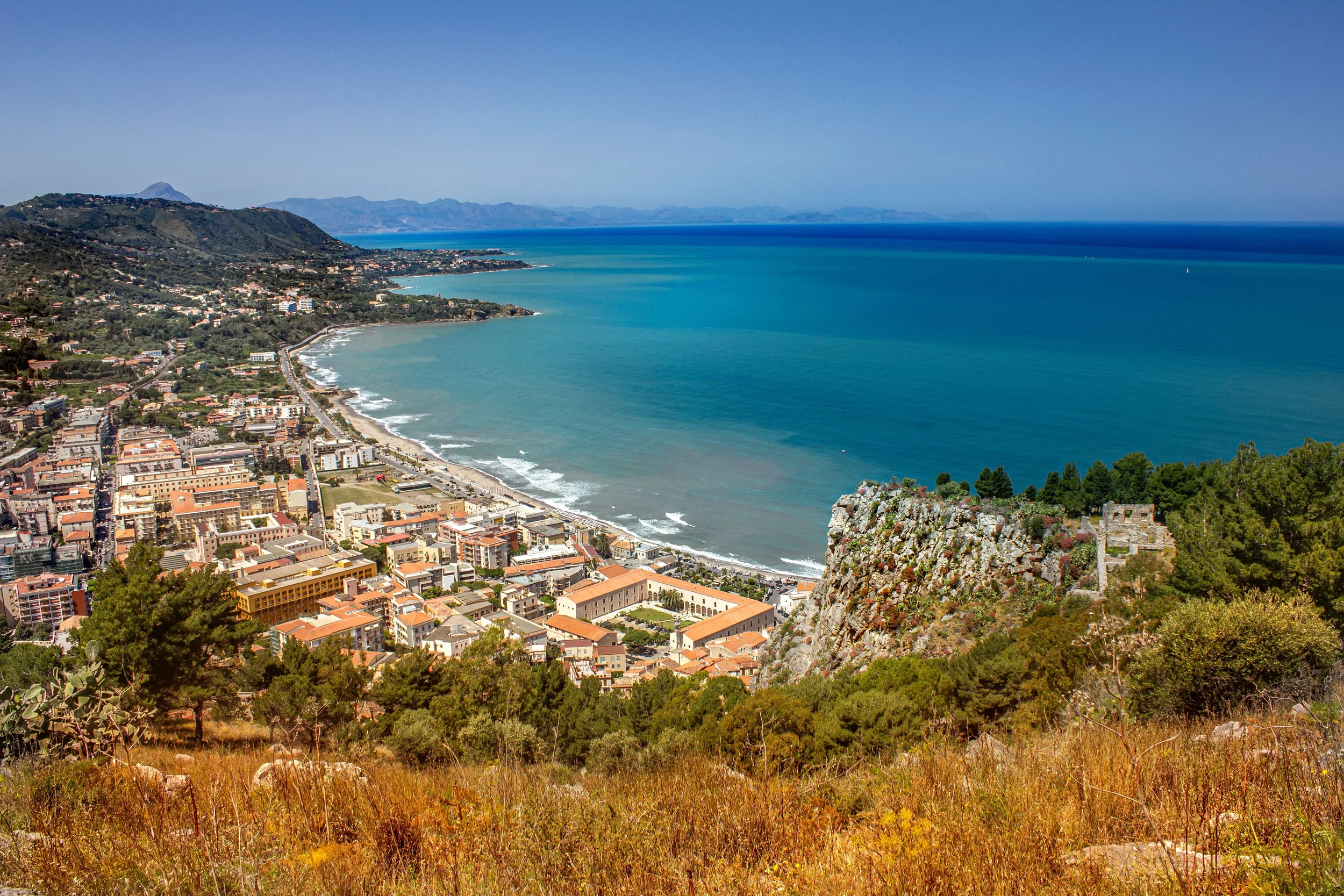 Aerial view of a coastal town and turquoise sea along the rugged Calabria coastline in southern Italy