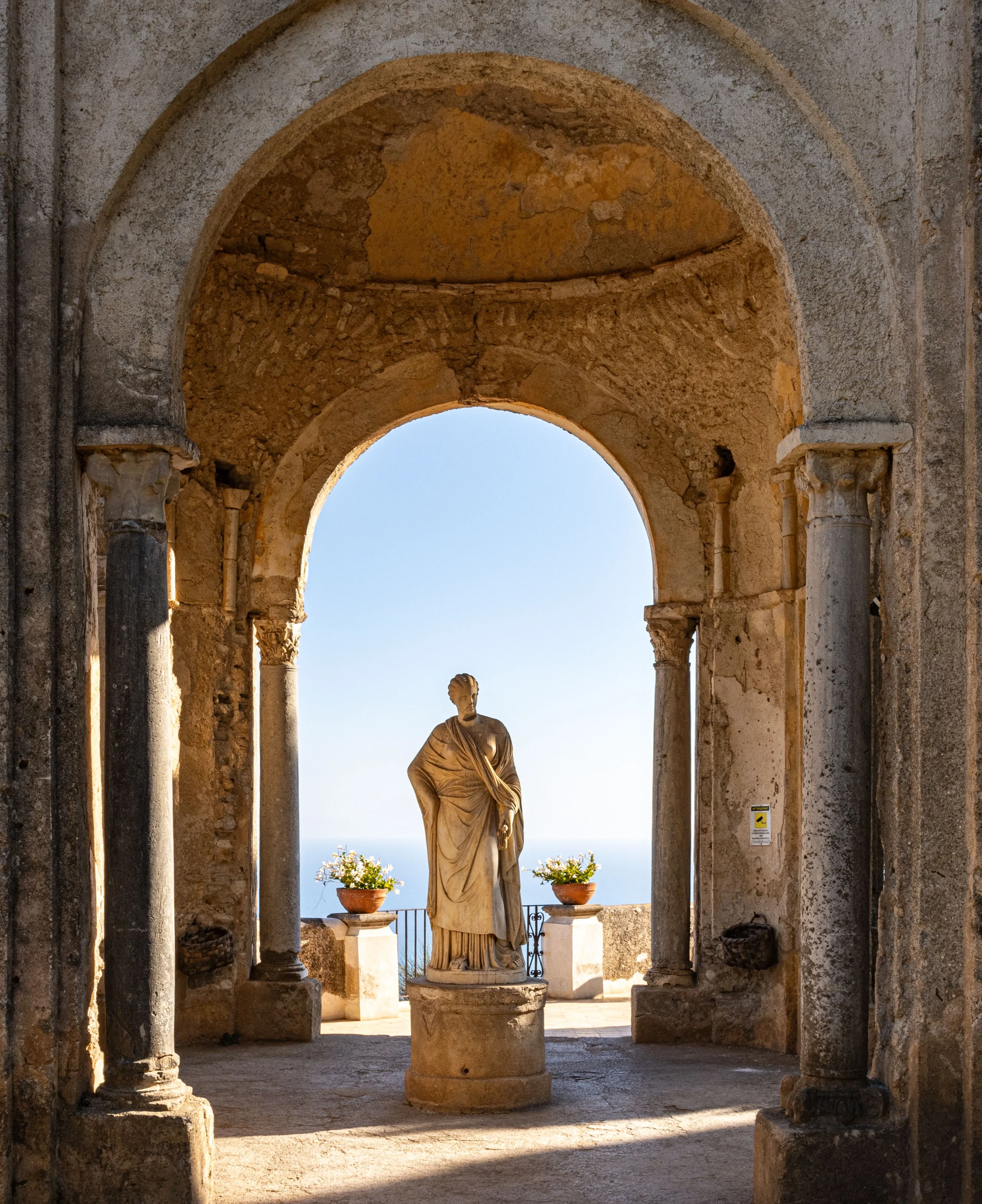 Historic stone arches and classical statue at Villa Rufolo in Ravello, overlooking the Amalfi Coast in Campania, Italy