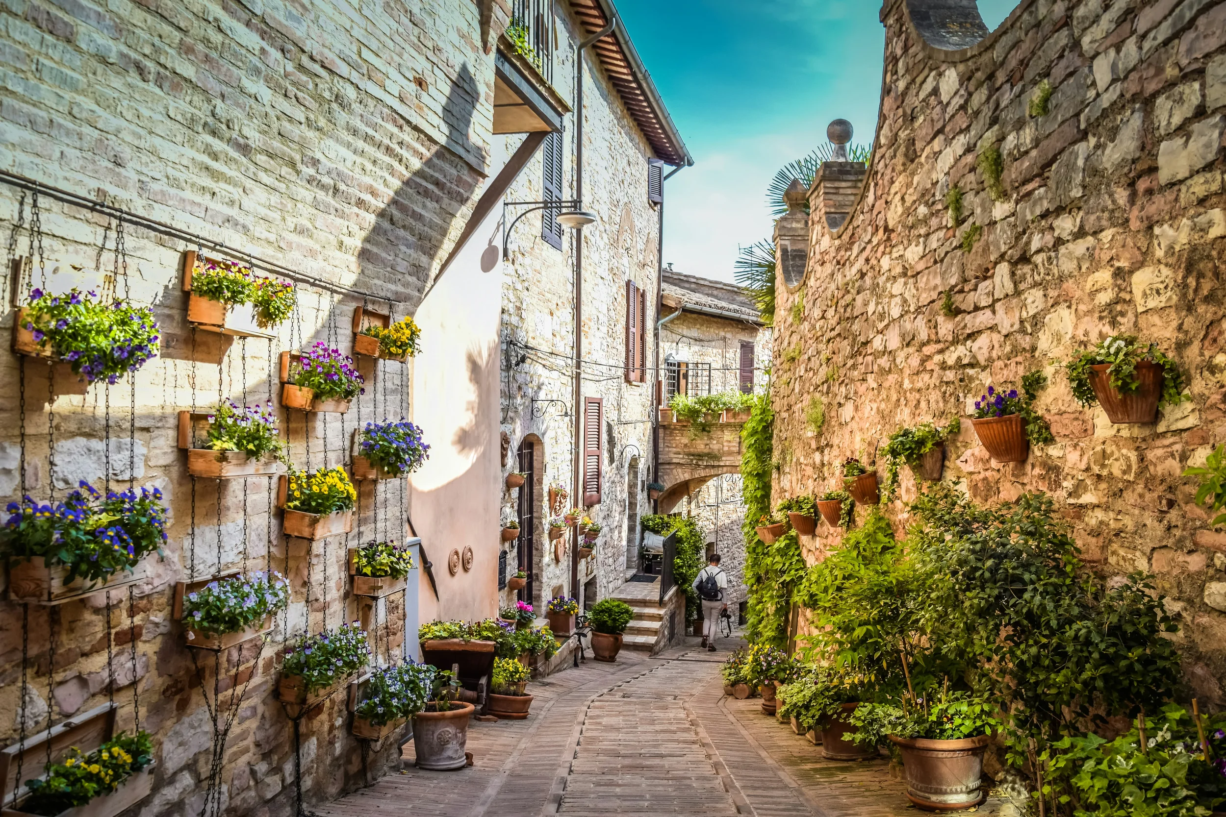 Flower-filled planters lining a narrow stone lane in Spello’s historic centre