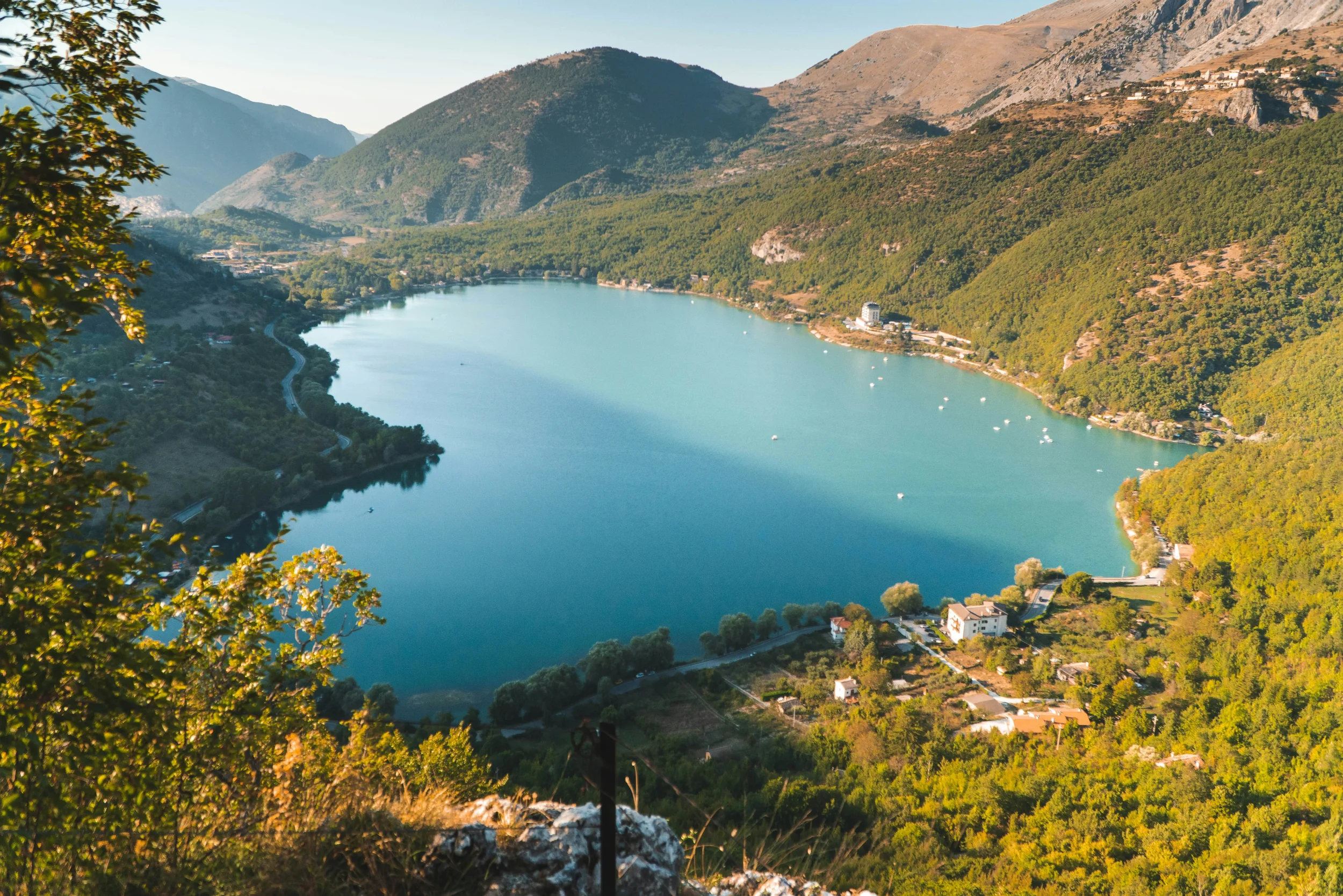 Turquoise Lake Scanno surrounded by wooded mountain slopes in Abruzzo.