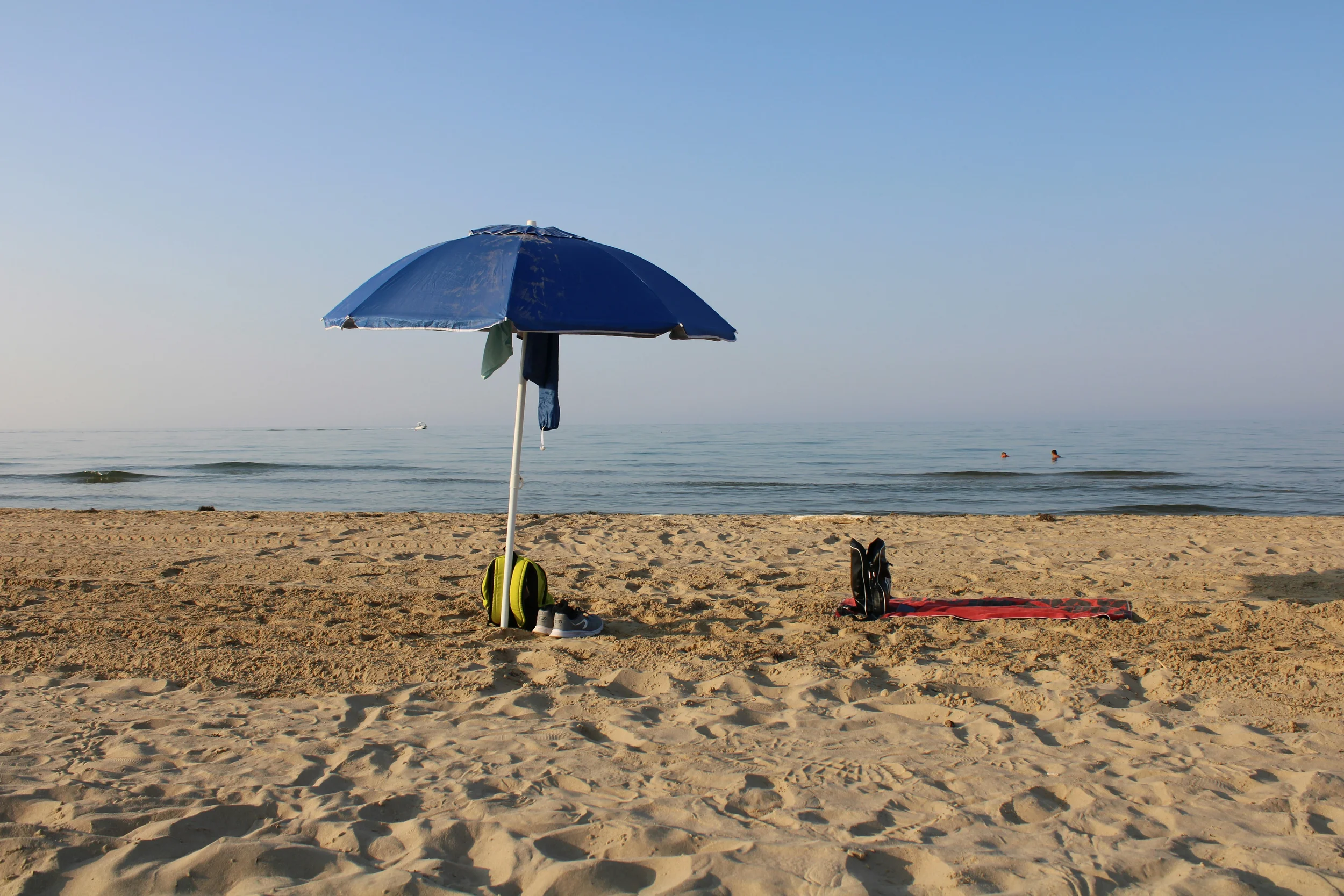 Blue beach umbrella and towels on a sandy beach beside the Adriatic Sea in Vasto, Abruzzo.