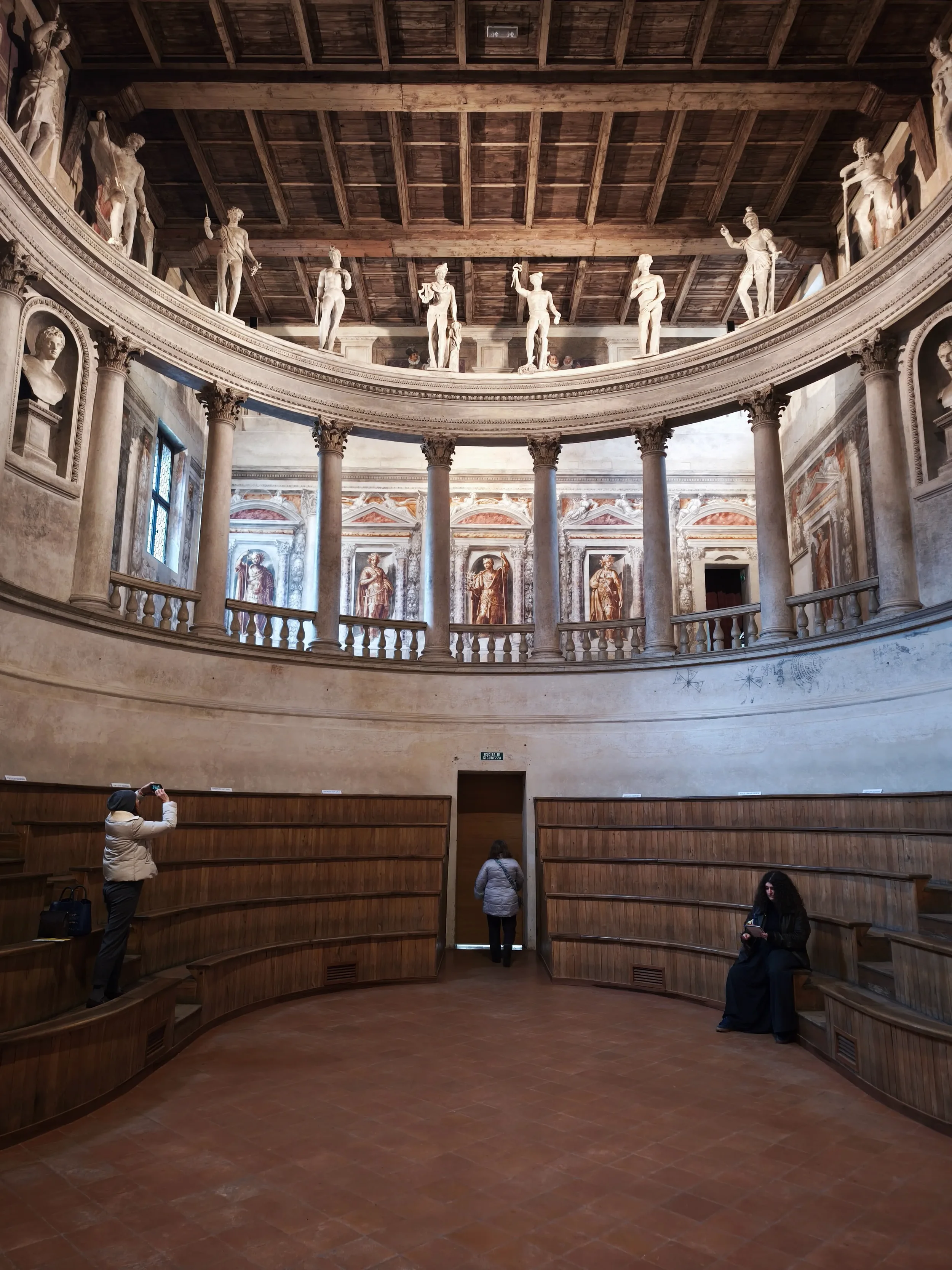 Curved wooden seating, painted walls and a statue-lined loggia inside Sabbioneta’s Teatro all’Antica.