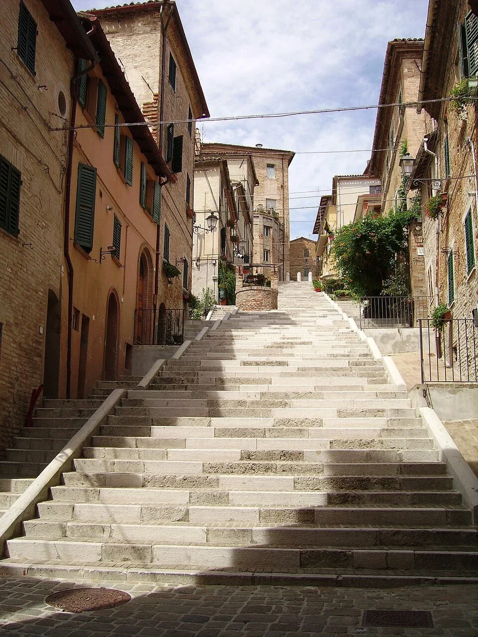 La Piaggia staircase climbing between brick houses and the well in Corinaldo