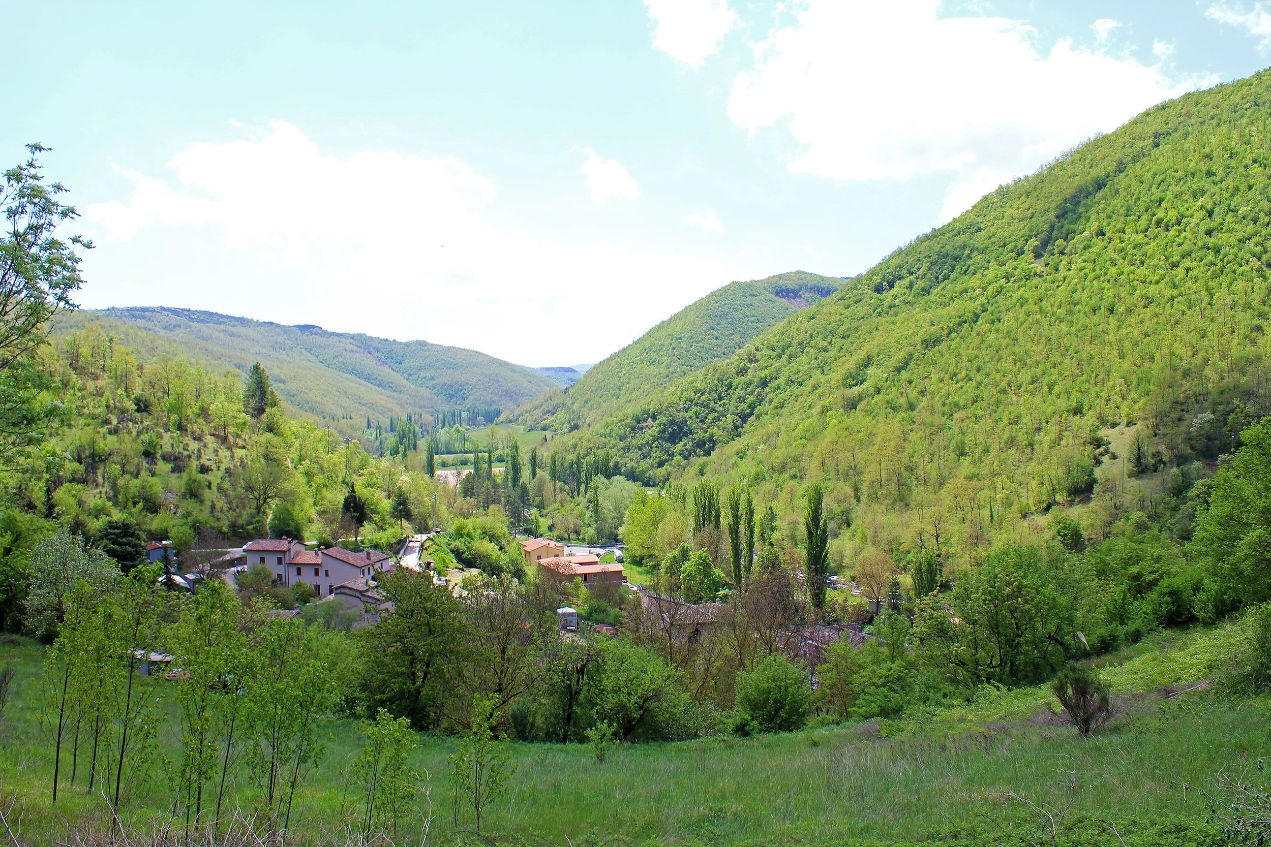 Rasiglia nestled below wooded hills in the Menotre Valley