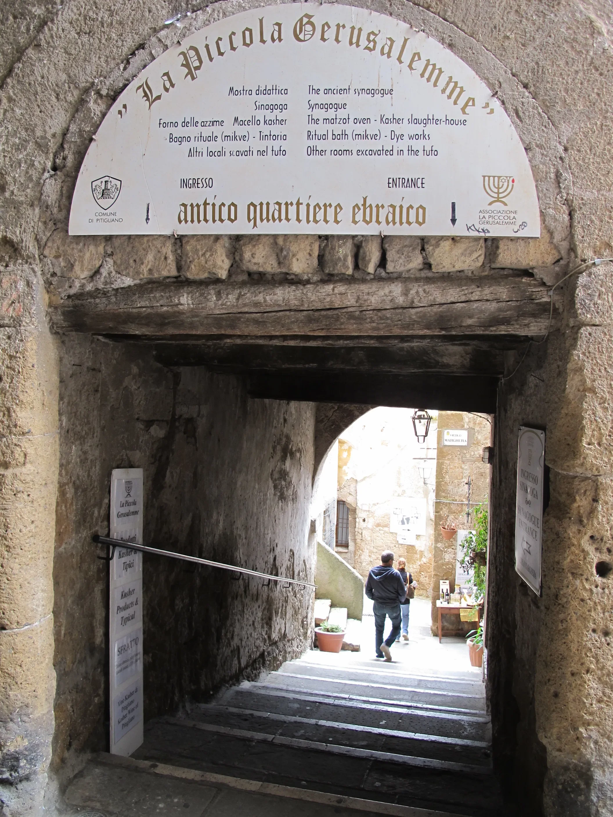 Stone steps beneath the La Piccola Gerusalemme sign at the entrance to Pitigliano’s historic Jewish Quarter.