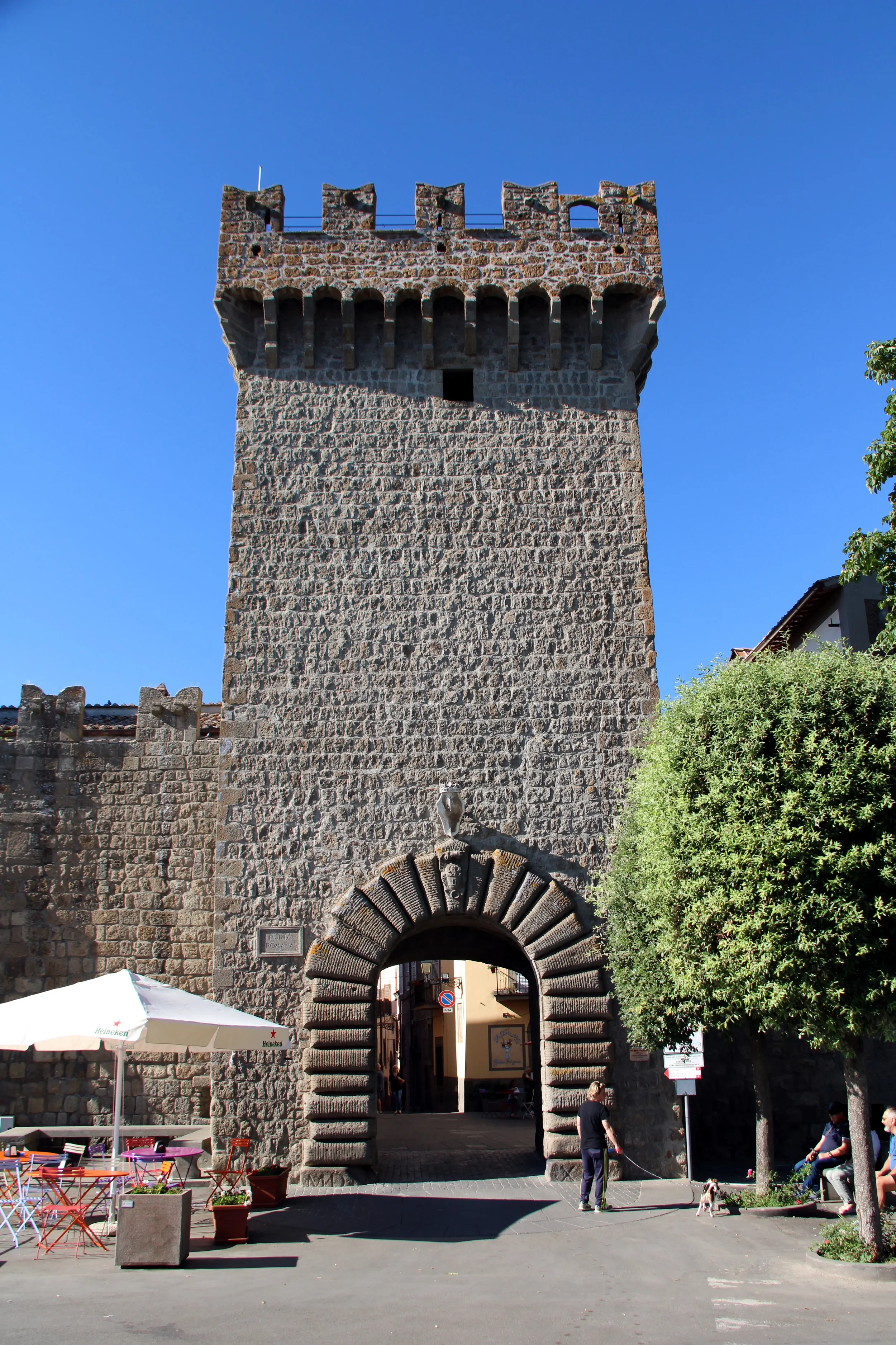 The battlemented stone tower and arched entrance of Porta Romana in Vitorchiano.