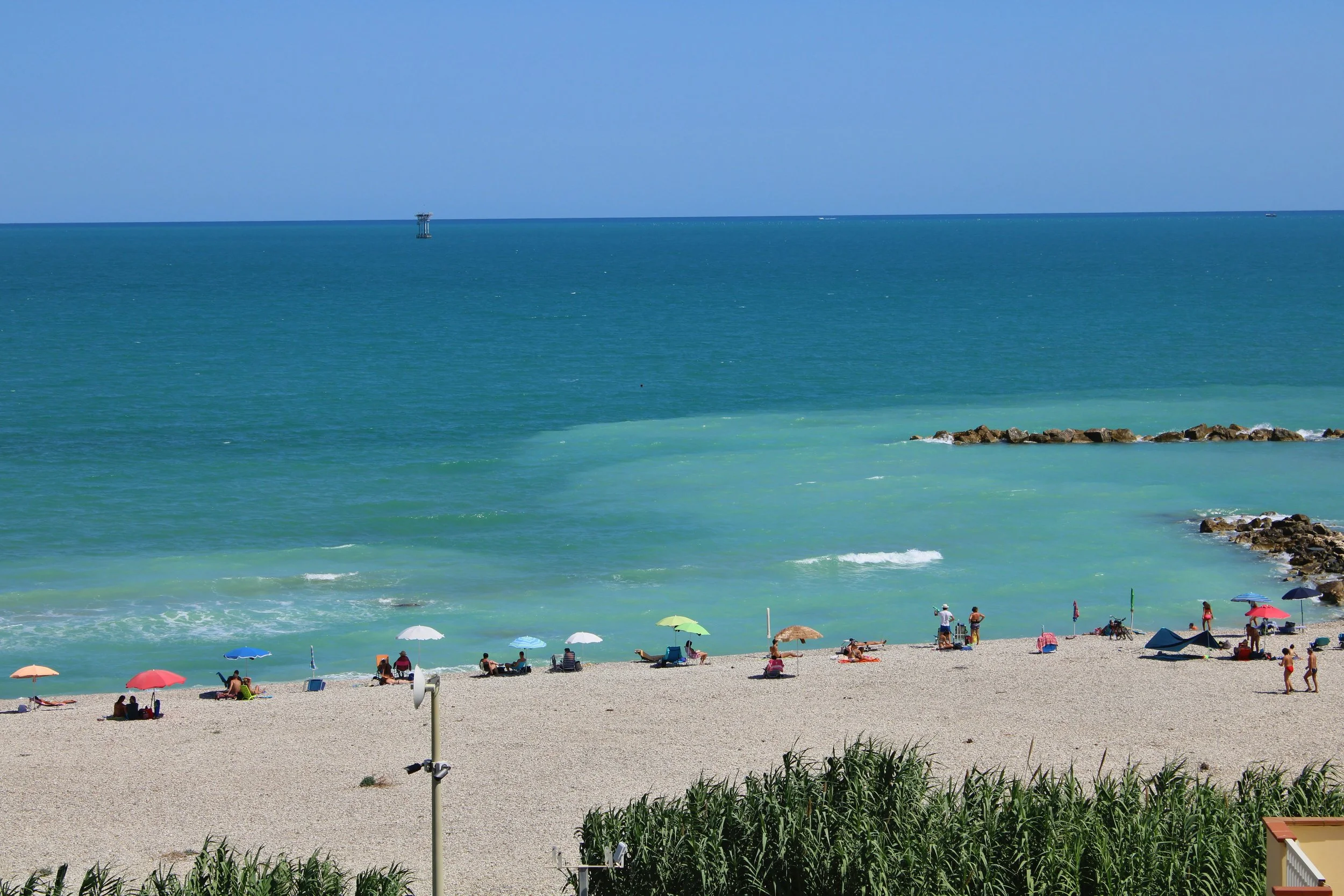 Pebble beach at Fossacesia Marina, with colourful umbrellas and turquoise Adriatic water.