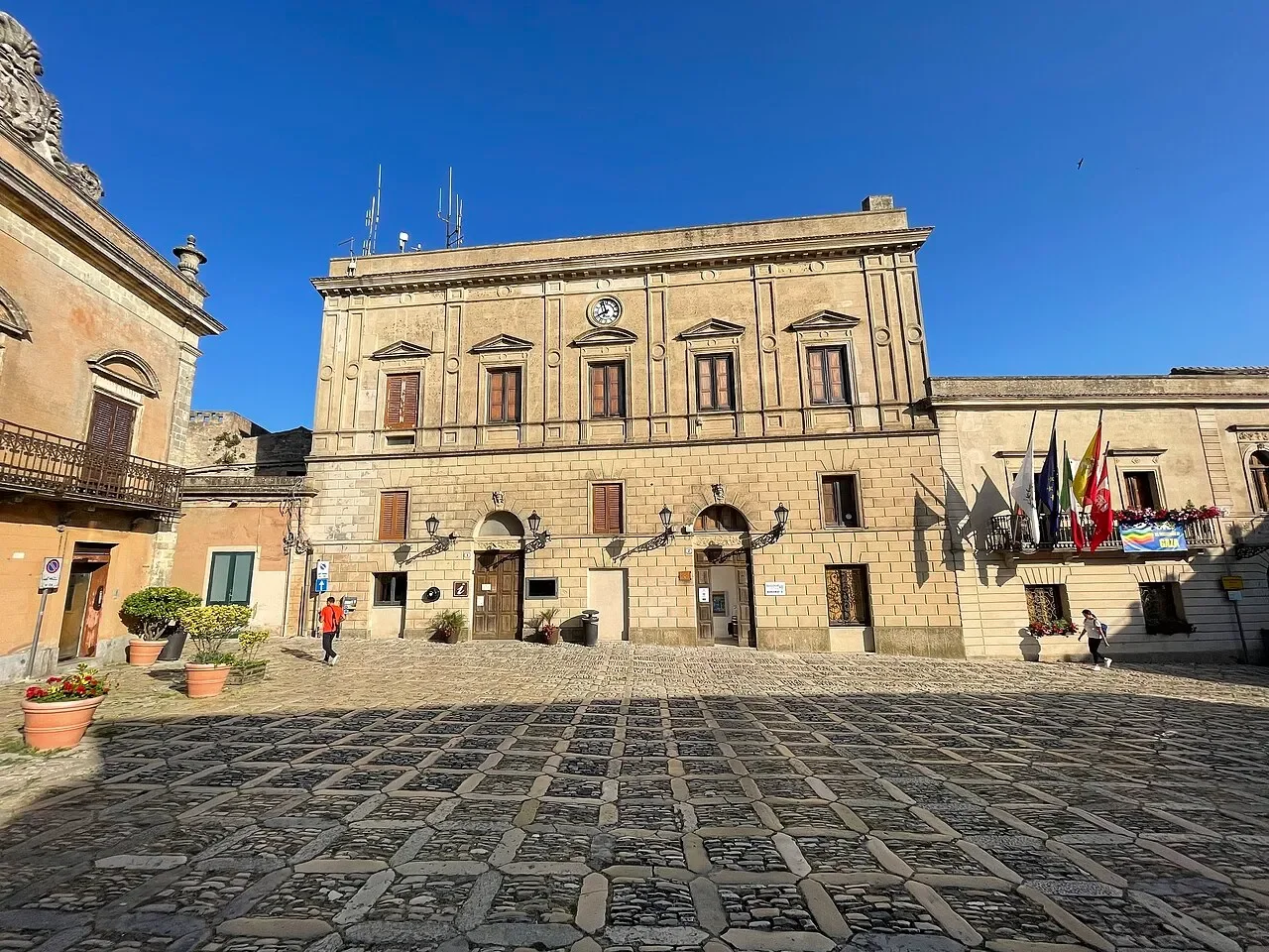 Patterned cobbles and historic façades in Piazza della Loggia, the main square of Erice