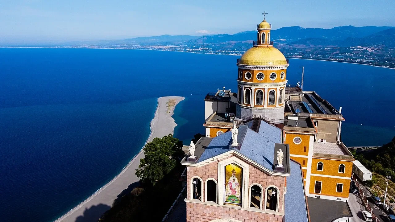 Aerial view of Tindari’s sanctuary above the blue Tyrrhenian Sea and the sand spit at Marinello