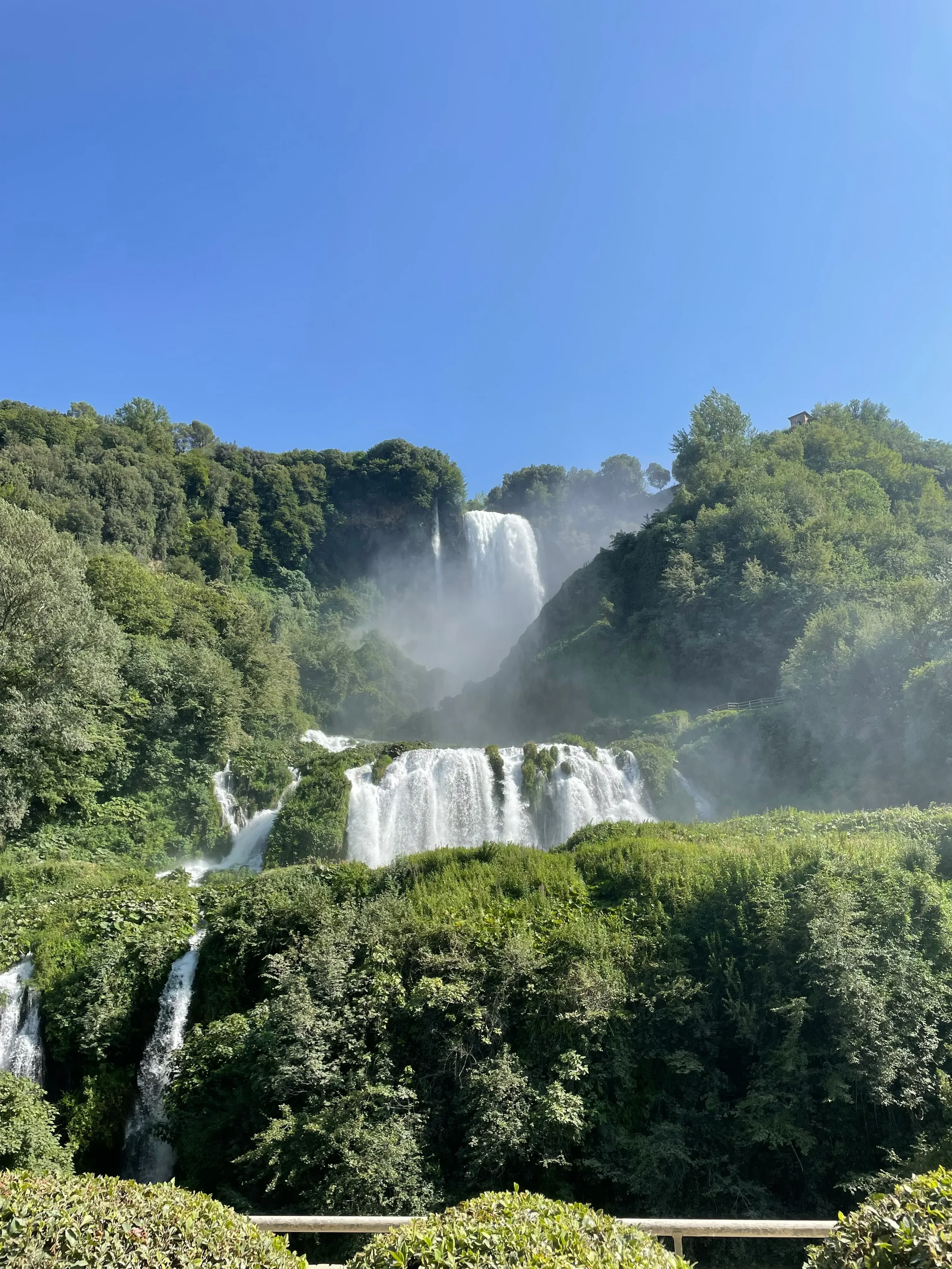 The upper and lower tiers of Marmore Falls beneath a clear blue sky