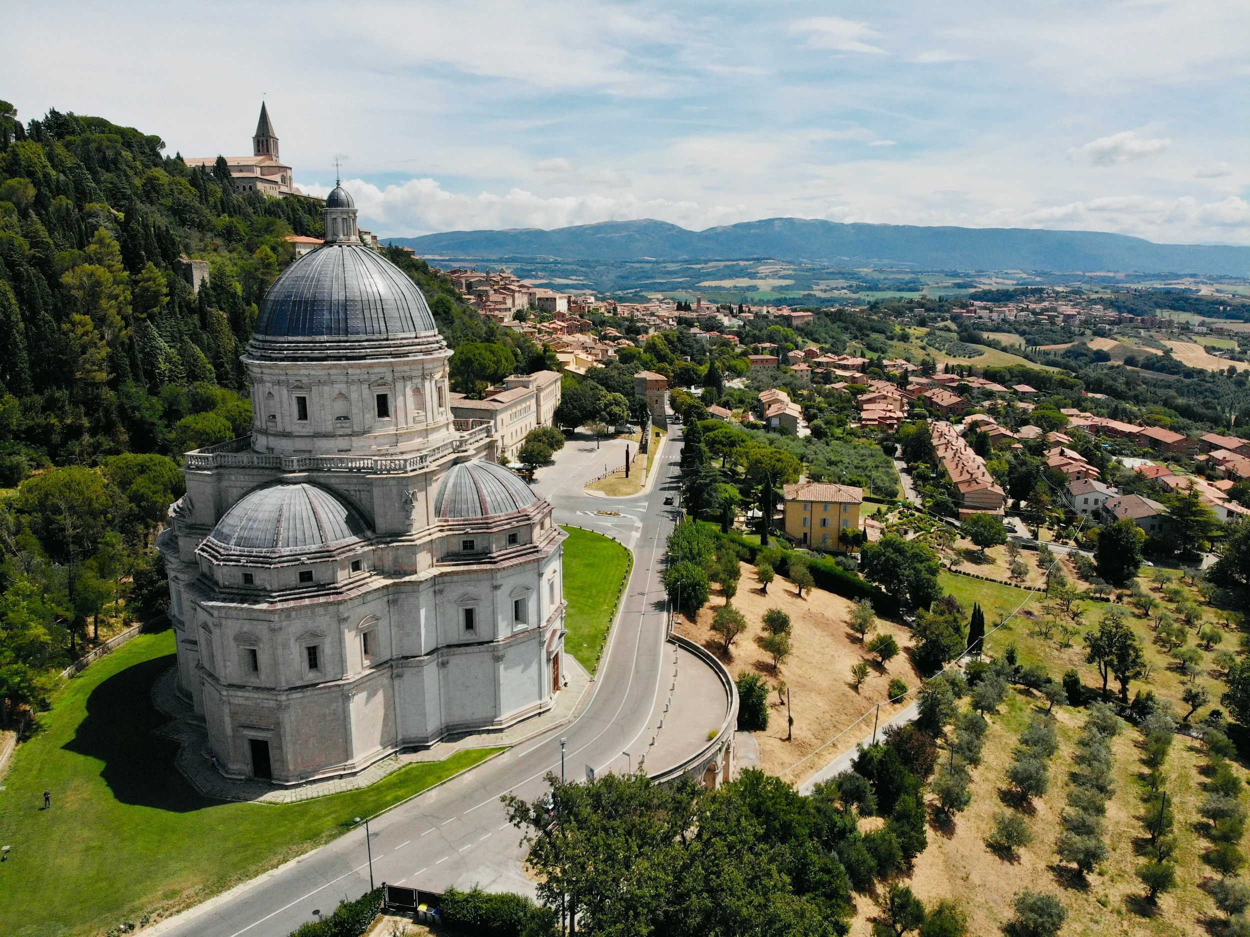 Aerial view of Santa Maria della Consolazione in Todi, with its domes overlooking the Umbrian countryside.