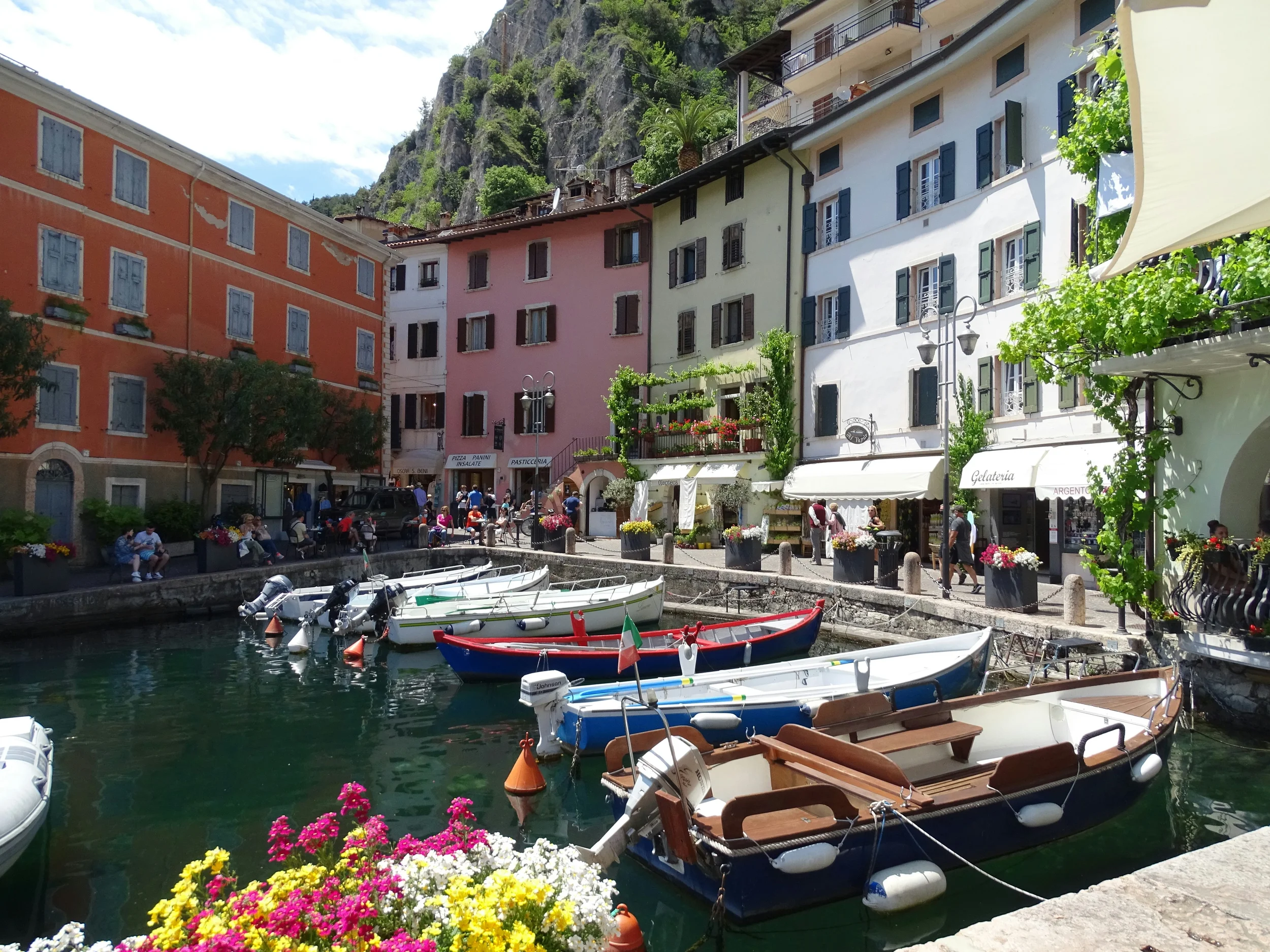 Colourful waterfront buildings and moored fishing boats in Limone sul Garda harbour