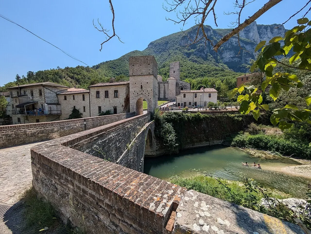 The stone bridge over the Sentino leading to the gate tower and abbey of San Vittore alle Chiuse