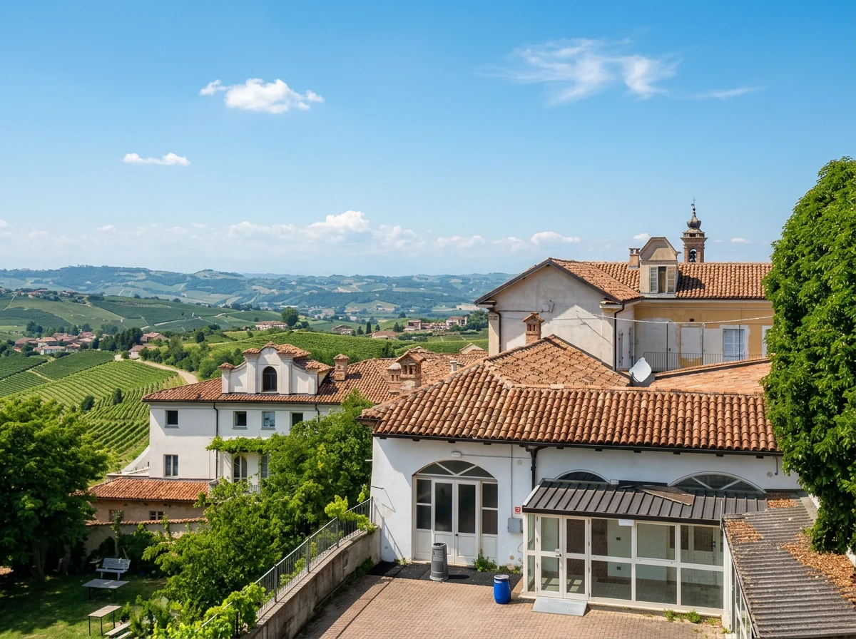 Terracotta rooftops in Neive overlooking the rolling vineyards of the Langhe beneath a blue sky.