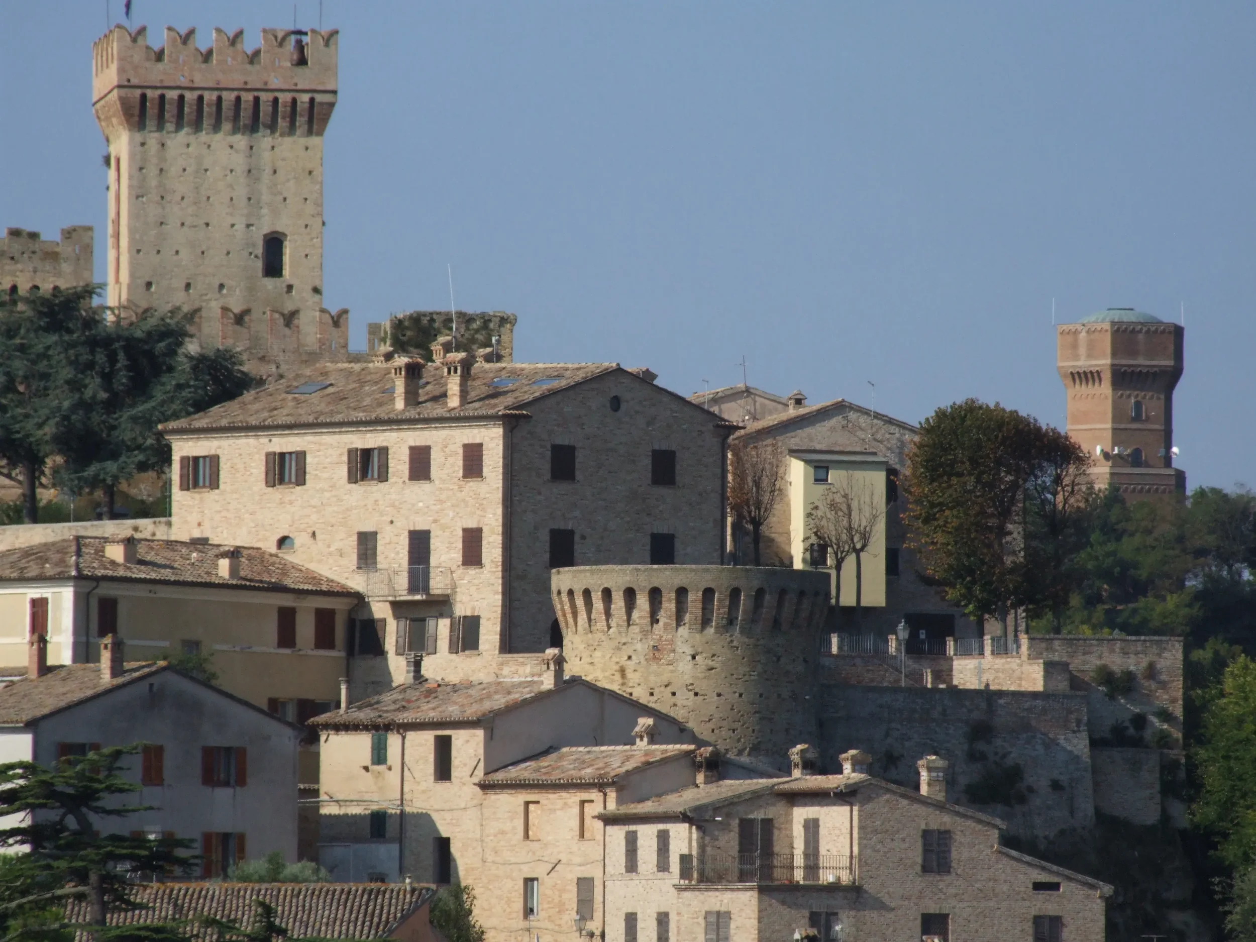 Stone houses and a round medieval tower below the Rocca in the hilltop village of Offagna