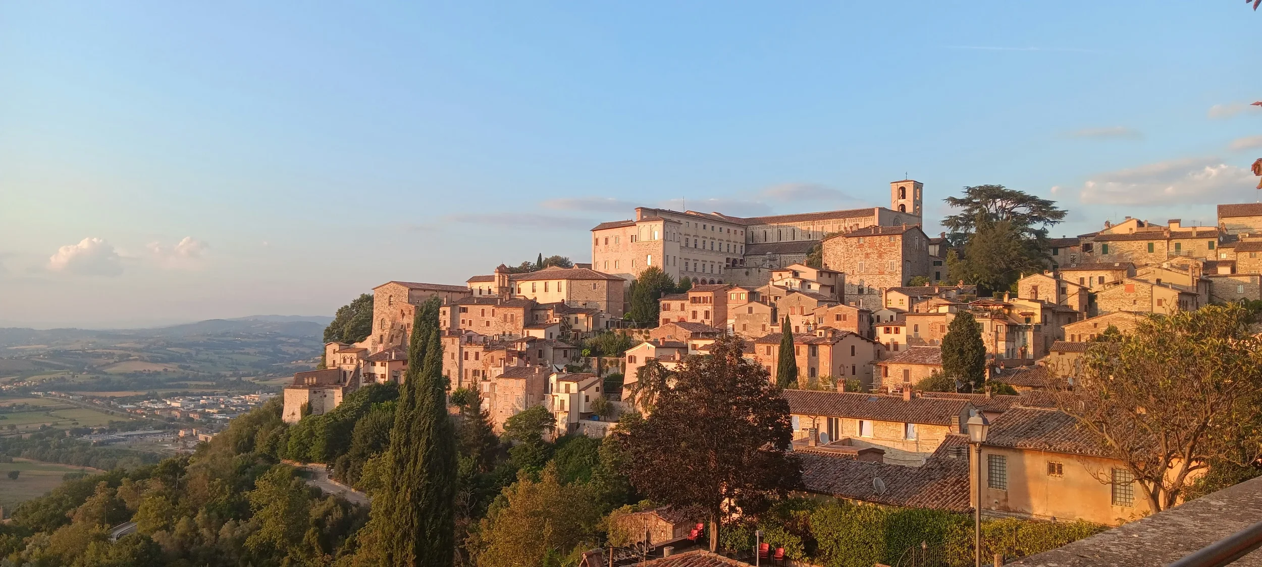 Hilltop town Narni in Umbria, with sunlit stone buildings, terracotta rooftops and views across the surrounding countryside.