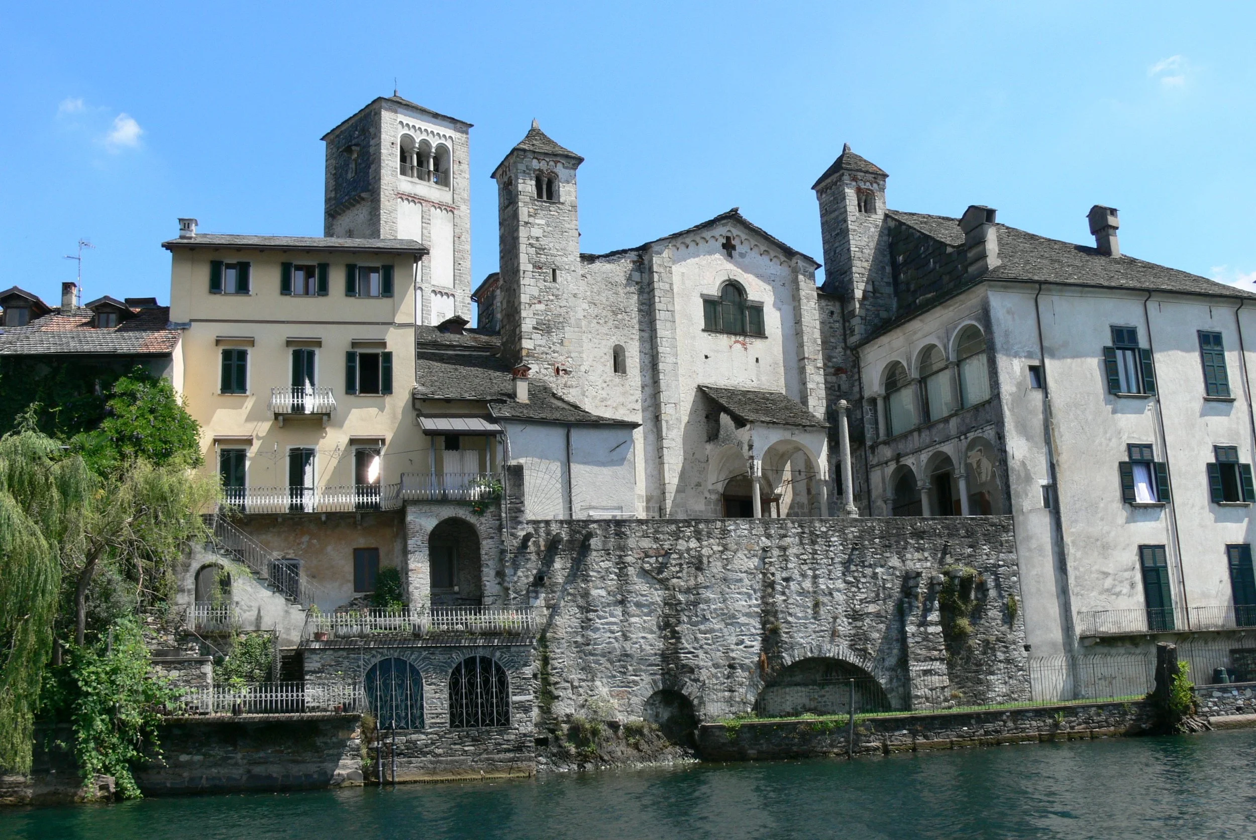 The Basilica di San Giulio and its stone towers viewed from the lakeshore.