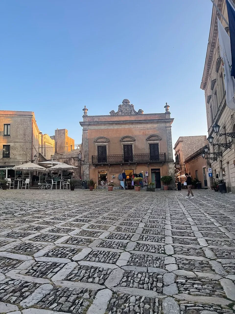 The Curatolo-Ragusa house across the patterned stone paving of Piazza della Loggia in Erice