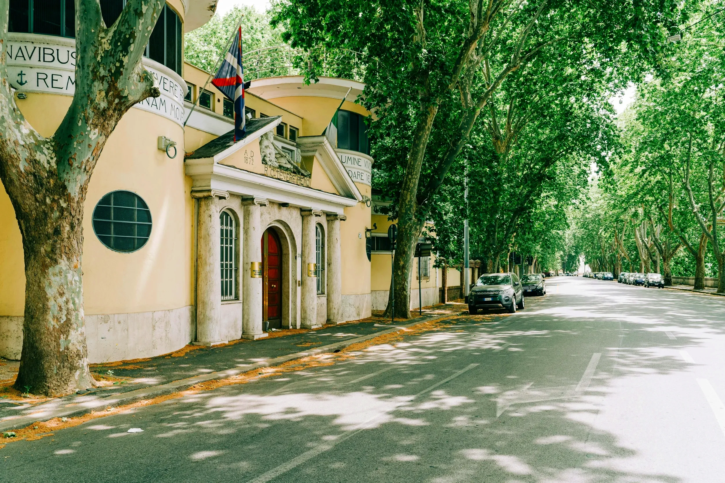 Tree-lined road in Lazio with historic buildings, capturing a scenic road trip through central Italy