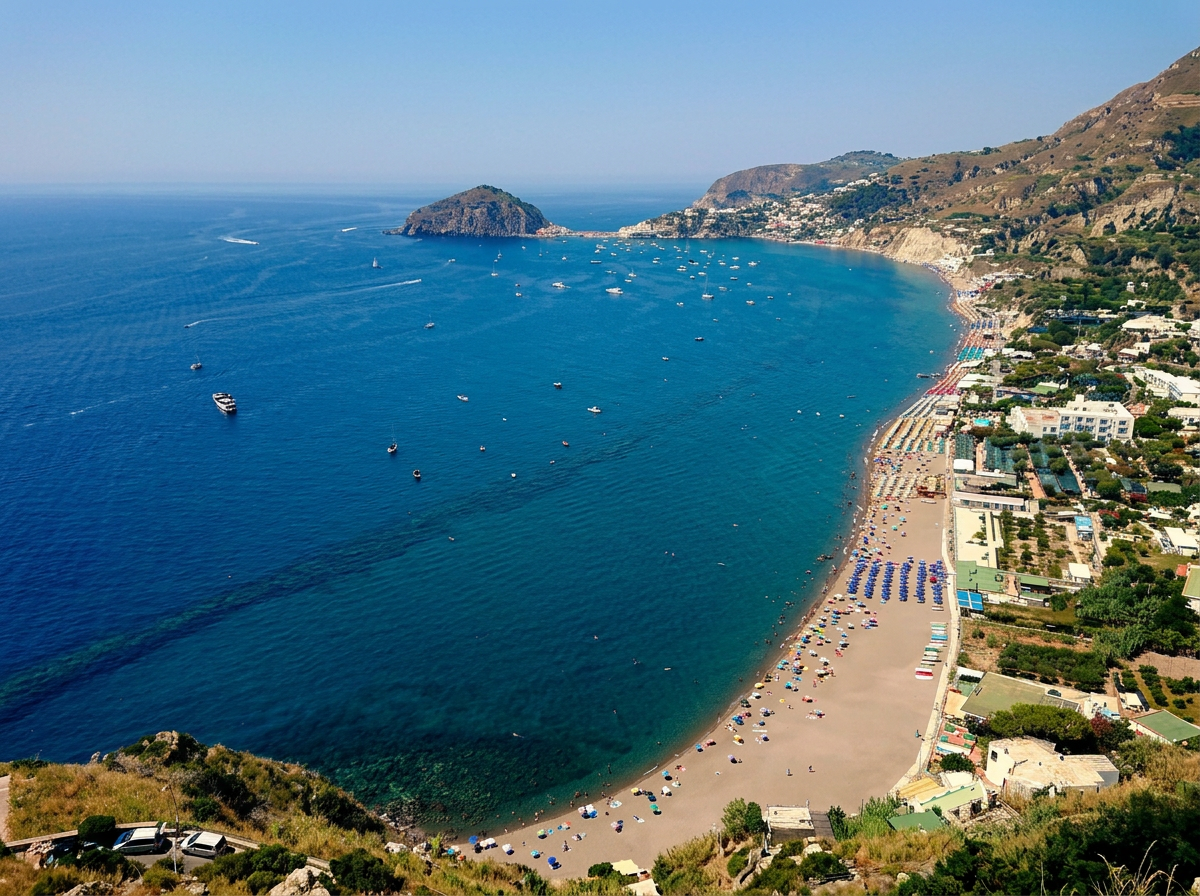 Maronti Beach on Ischia with a long volcanic shoreline and Sant’Angelo in the distance, Campania