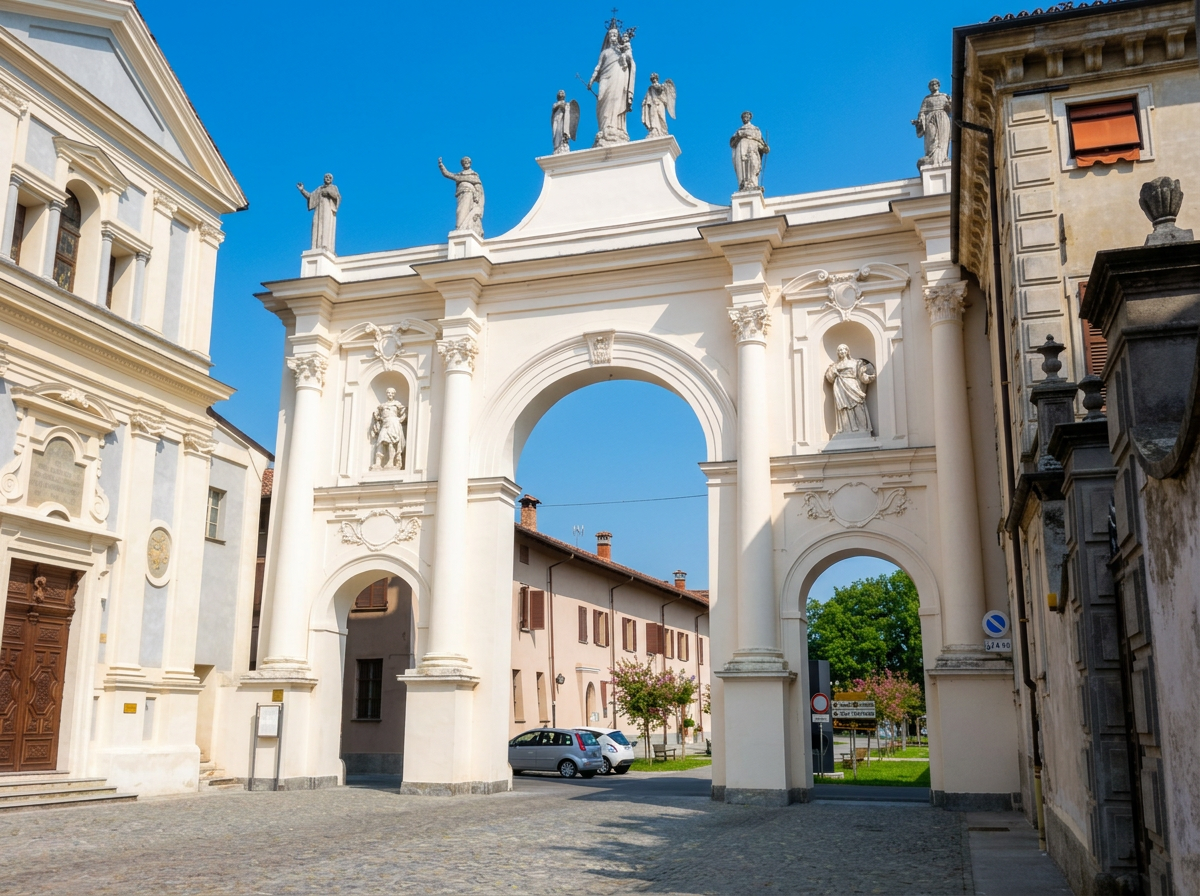Arco del Belvedere in Cherasco, with white arches, sculpted columns and statues beneath a blue sky.