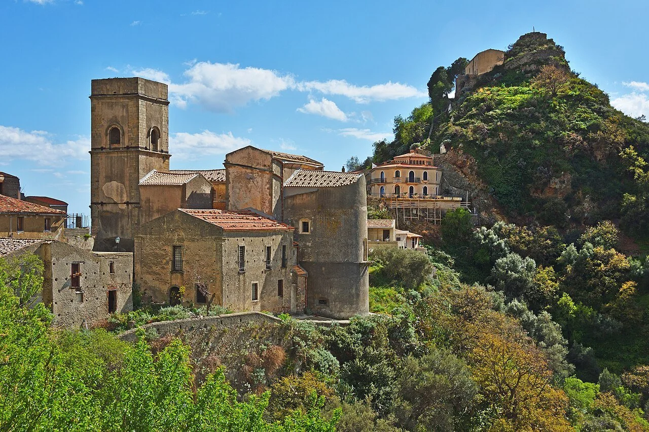 Santa Maria in Cielo Assunta church and its square bell tower beneath the rocky hilltop of Savoca