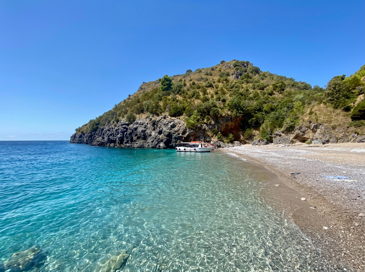 Baia degli Infreschi with turquoise water, a secluded pebble beach and rugged green cliffs along the Cilento Coast in Campania, Italy