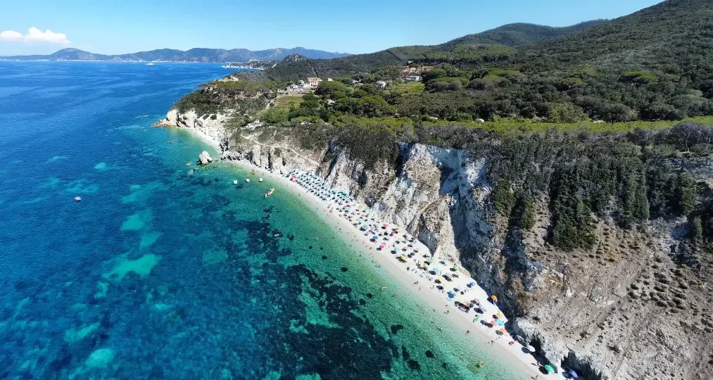 Aerial view of Spiaggia di Sansone on Elba Island, with white cliffs, a pebble beach and crystal-clear turquoise water