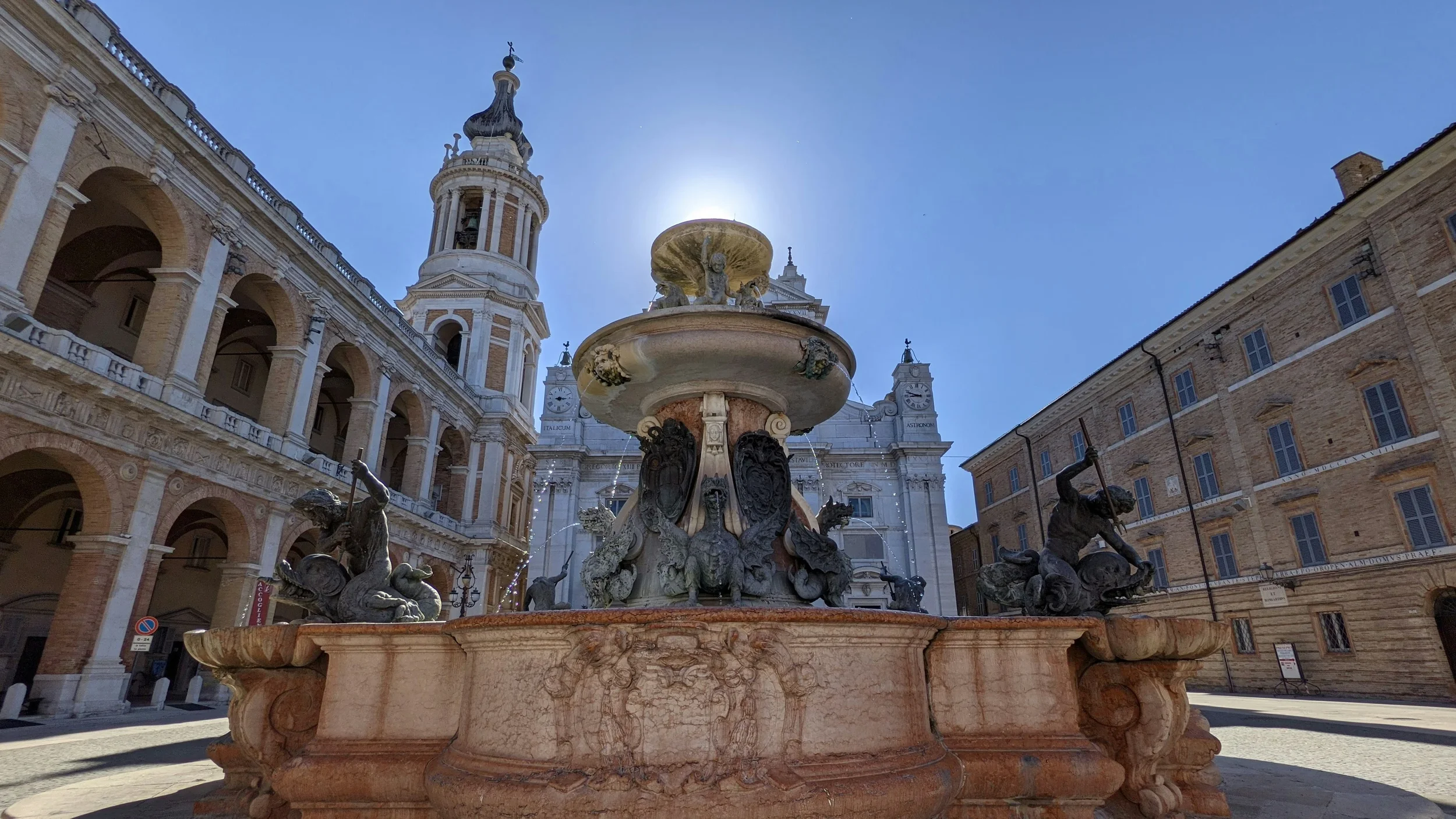 Ornate fountain in Piazza della Madonna with the Basilica della Santa Casa in Loreto, Le Marche, Italy
