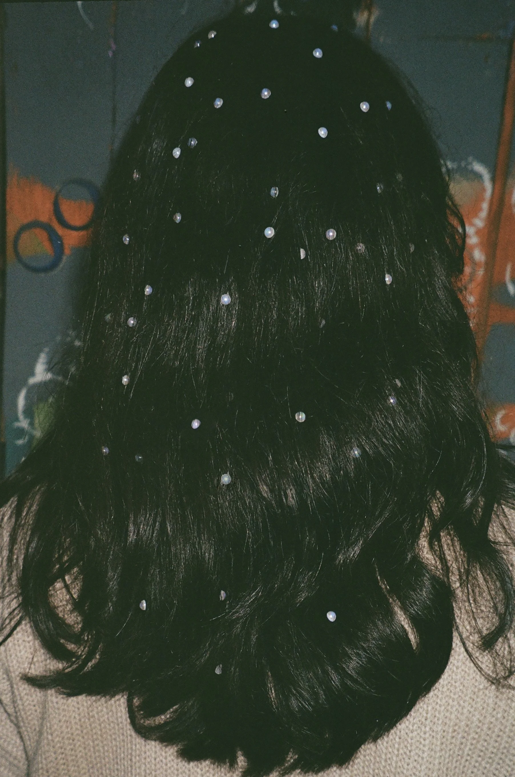 Black wig with pearl and rhinestone embellishments, displayed on a mannequin head.